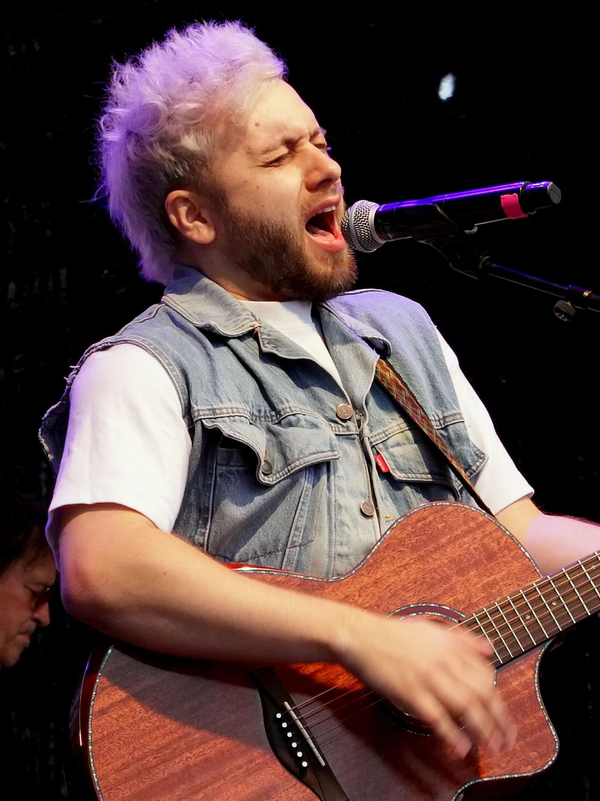 Auf dem Bild ist ein Musiker mit Gitarre zu sehen.