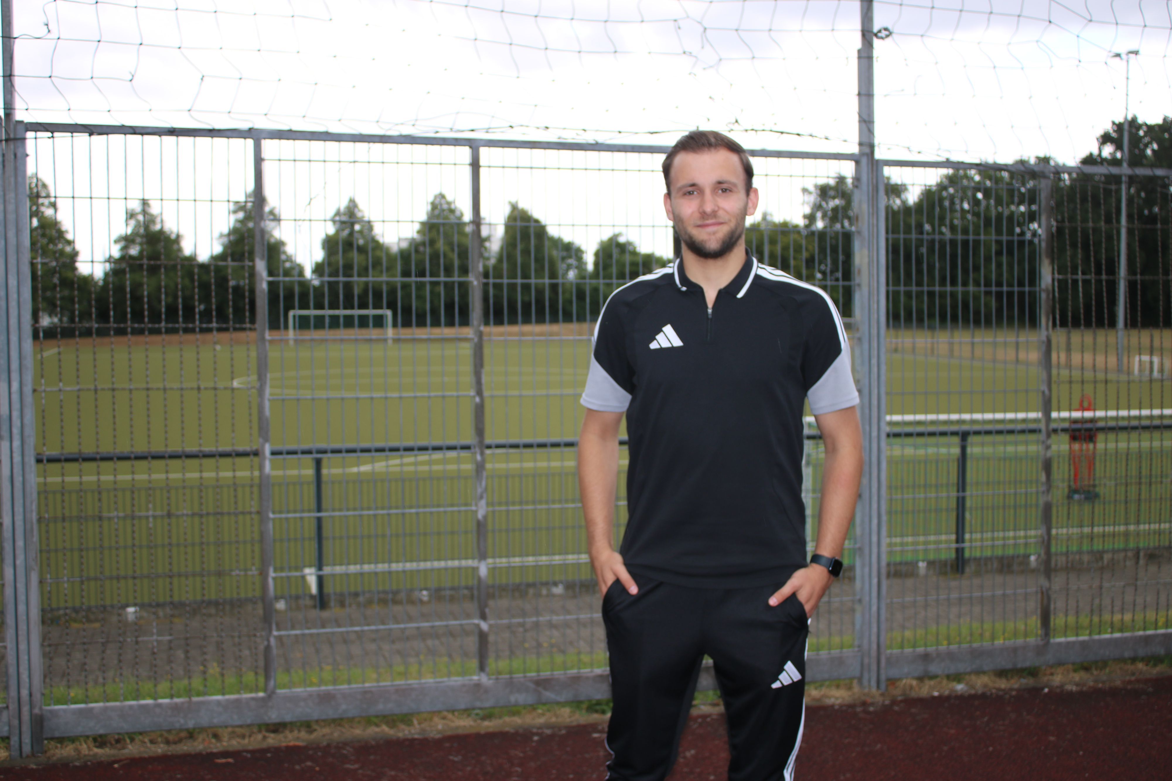 Schiedsrichter Noah Straeten vor den Fußballplatz.