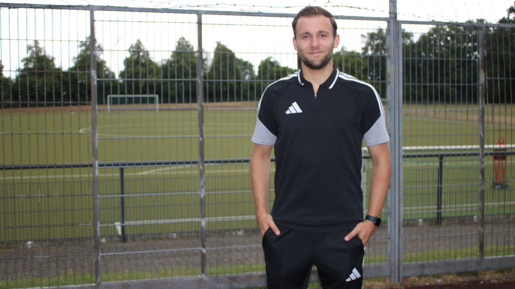 Schiedsrichter Noah Straeten vor den Fußballplatz.