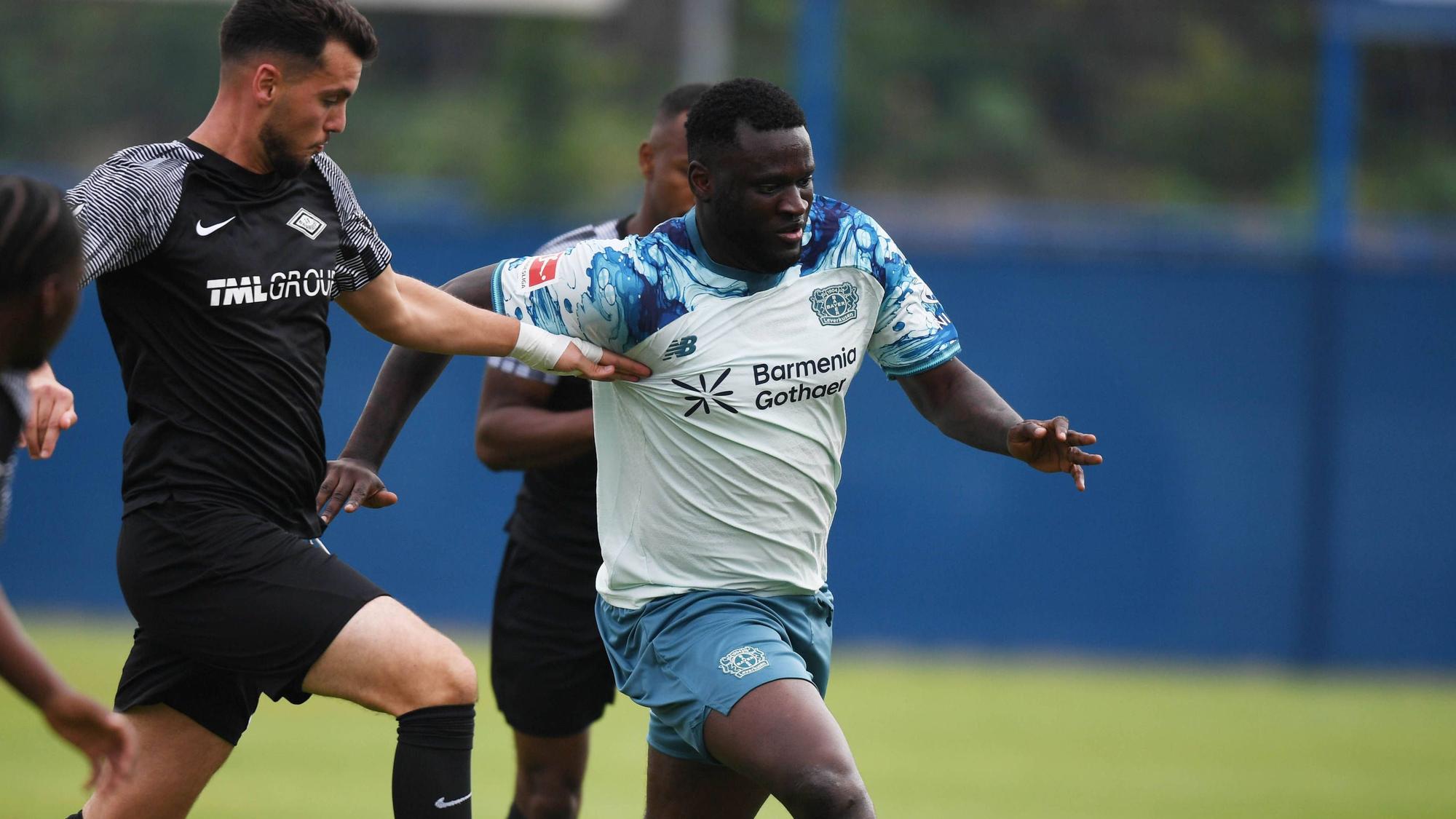 Victor Boniface wird am Trikot gehalten.