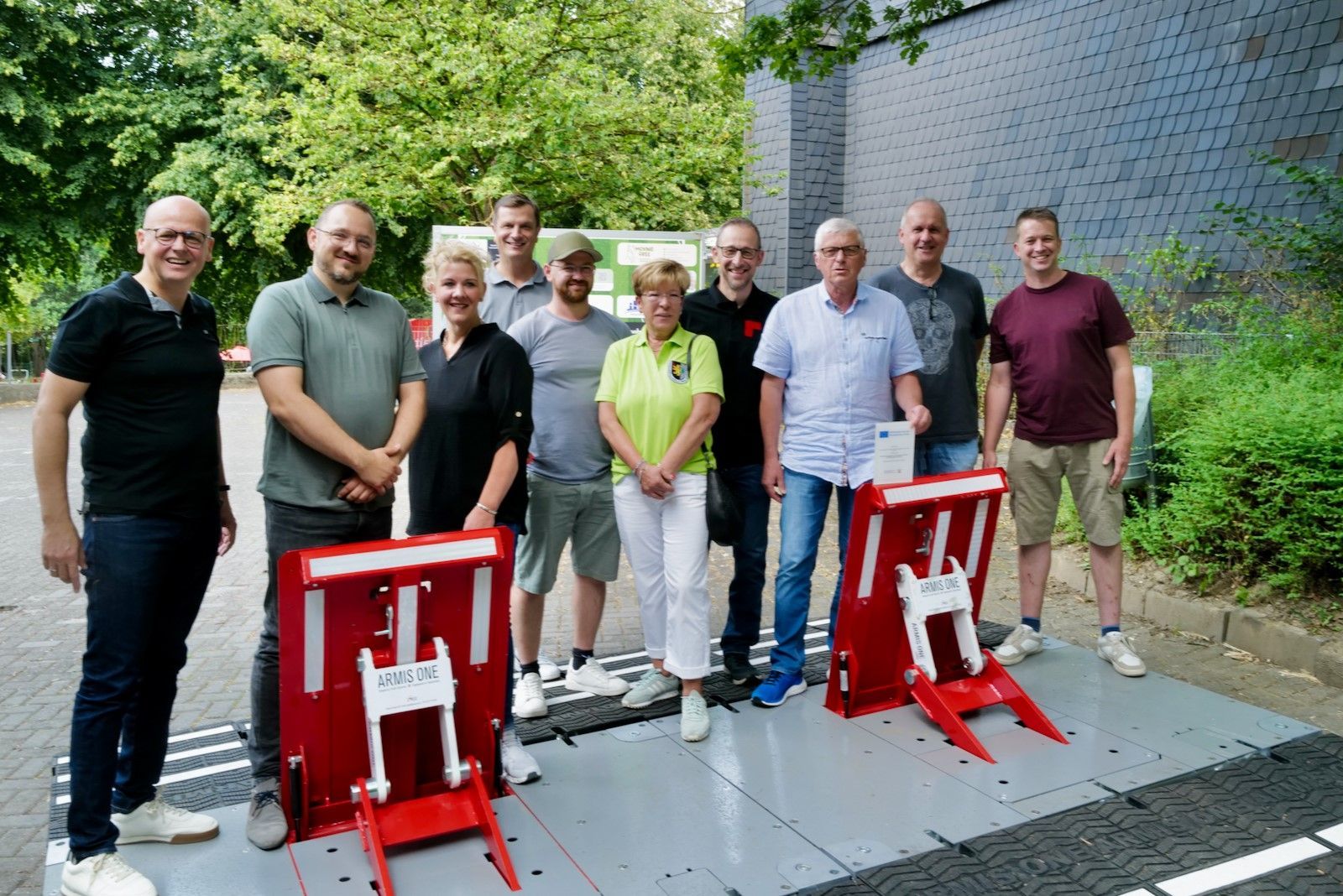 Männer und Frauen stehen hinter beweglichen Sicherheitselementen.