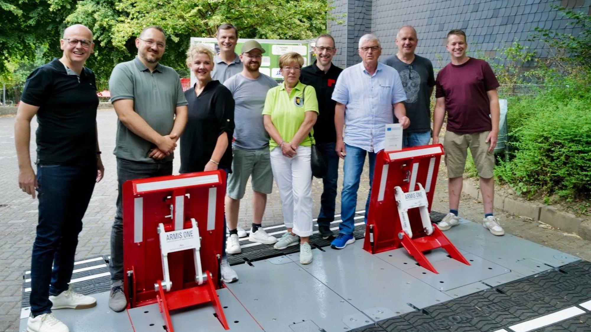 Männer und Frauen stehen hinter beweglichen Sicherheitselementen.