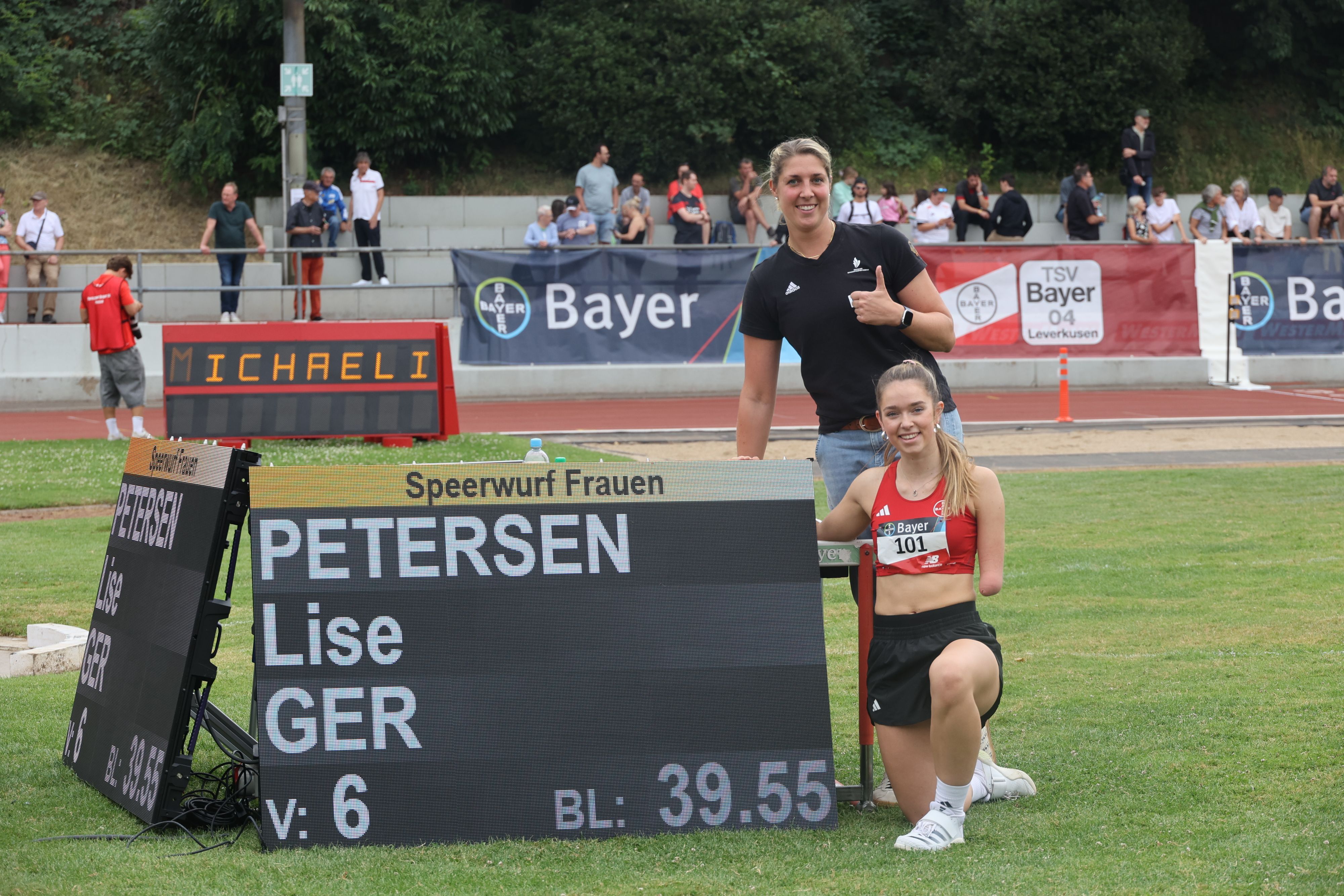 Lise Petersen und Kira Biesenbach neben der Ergebnisanzeigetafel des Rekordwurfes.