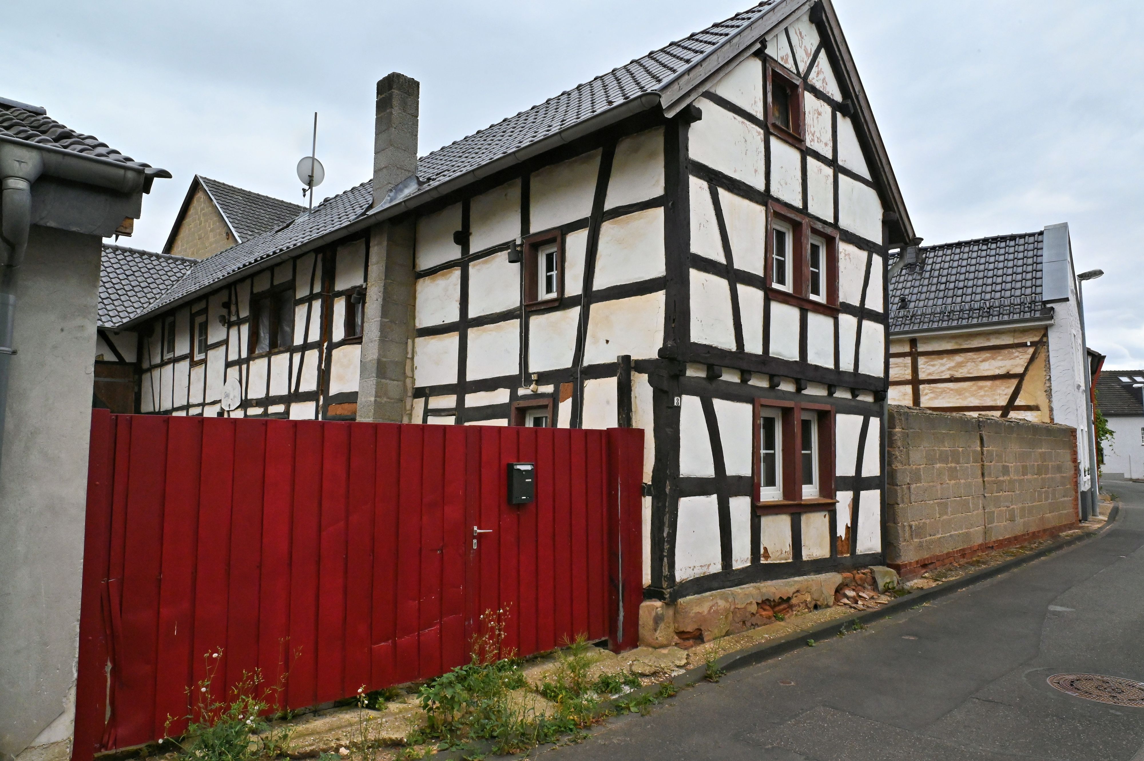 An der Agathastraße in Schaven steht ein sanierungsbedürftiges Fachwerkhaus mit einem roten Hoftor, das zu einem Dorfgemeinschaftshaus umgebaut werden soll.