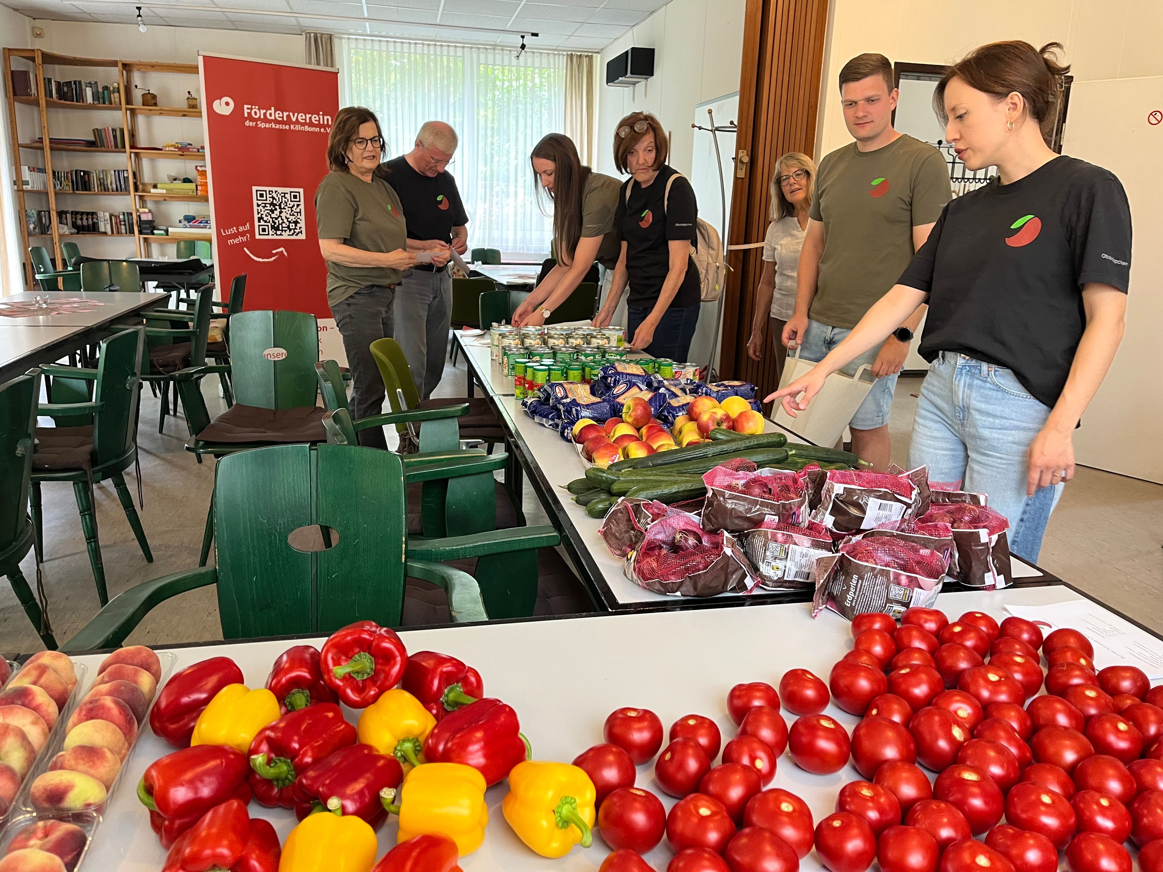 Obstkäppchen-Gründerin Carina Raddatz (r.) und das Unterstützungsteam beim Packen der Lebensmittelbeutel, die einmal im Monat zu bedürftigen Senioren in Porz gebracht werden.