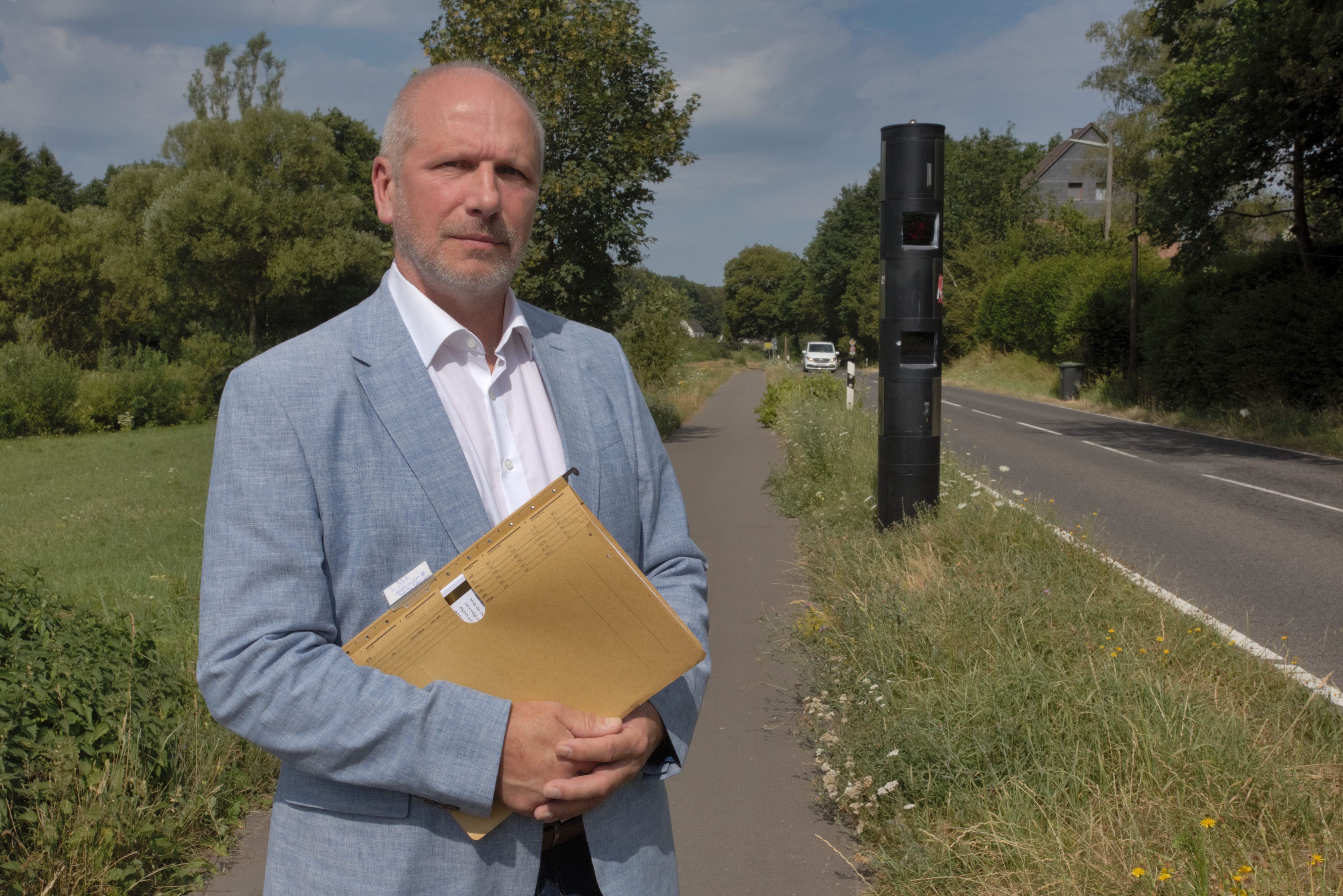 Das Foto zeigt Rechtsanwalt Volker Steffen aus Nümbrecht-Niederbröl vor dem fest installierten
Blitzer an der Landesstraße 339.
