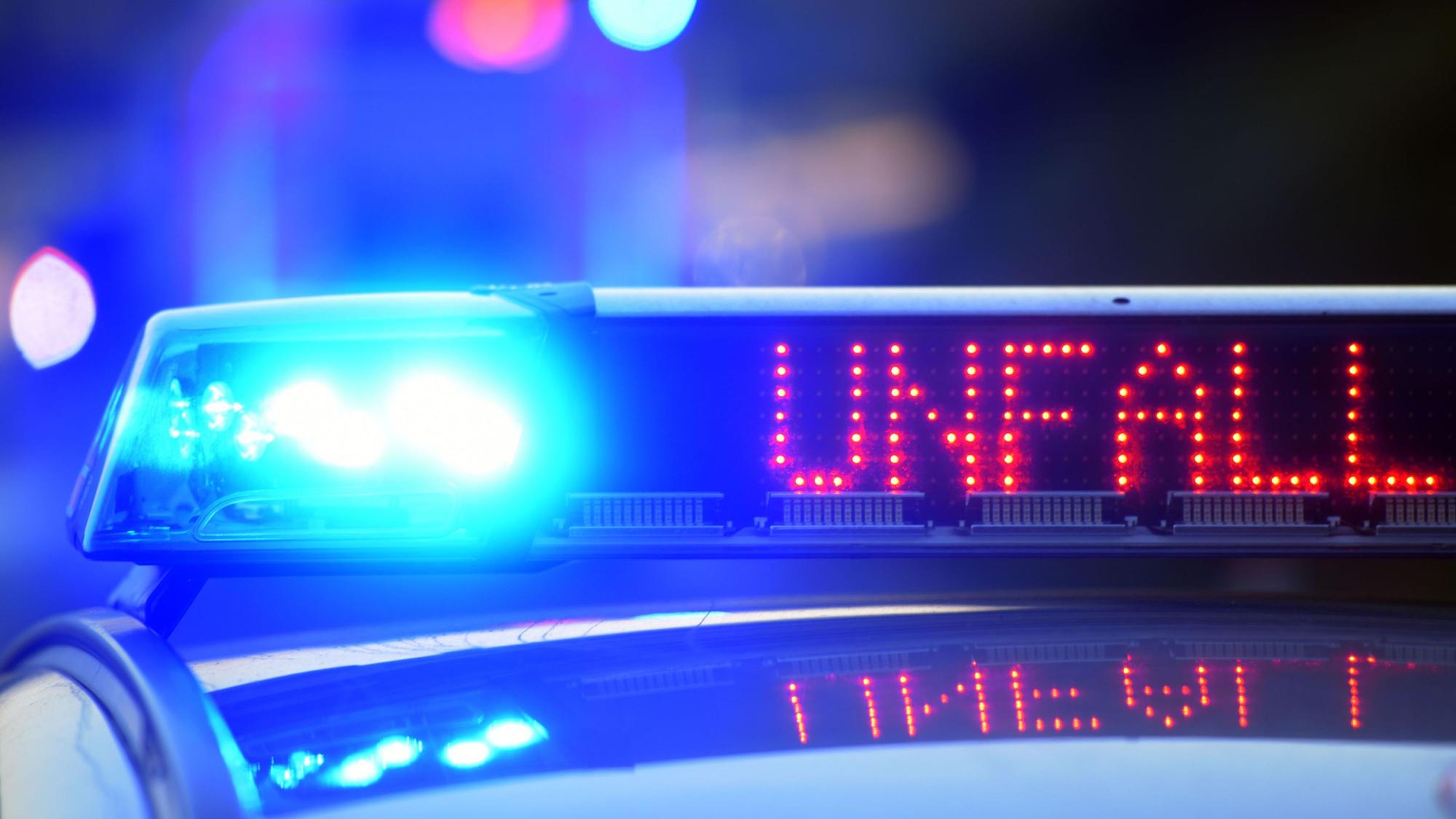 Auf einem Polizeifahrzeug warnt auf der Autobahn eine Leuchtschrift vor einer Unfallstelle.