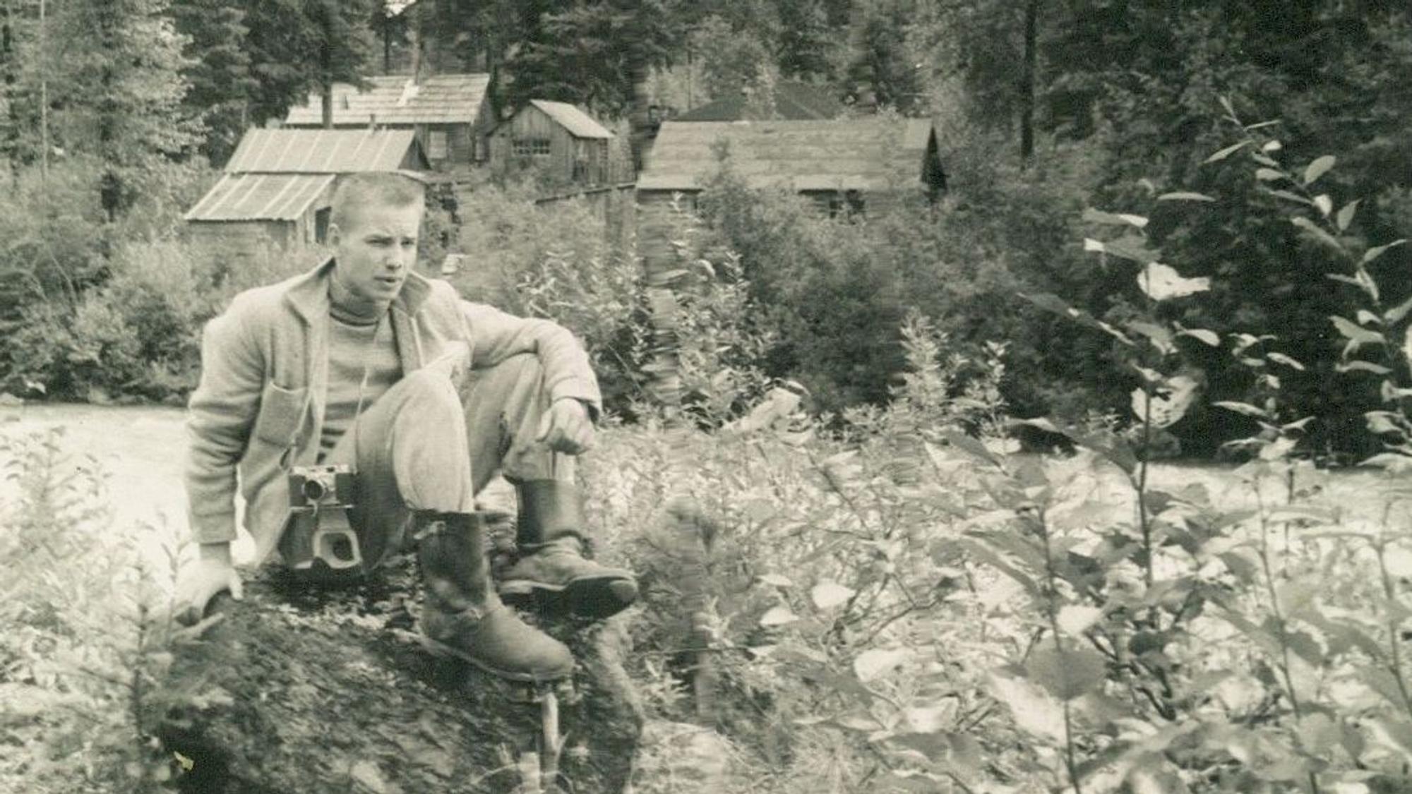 Schwarzweißbild eines jungen Mannes in wilder Landschaft.