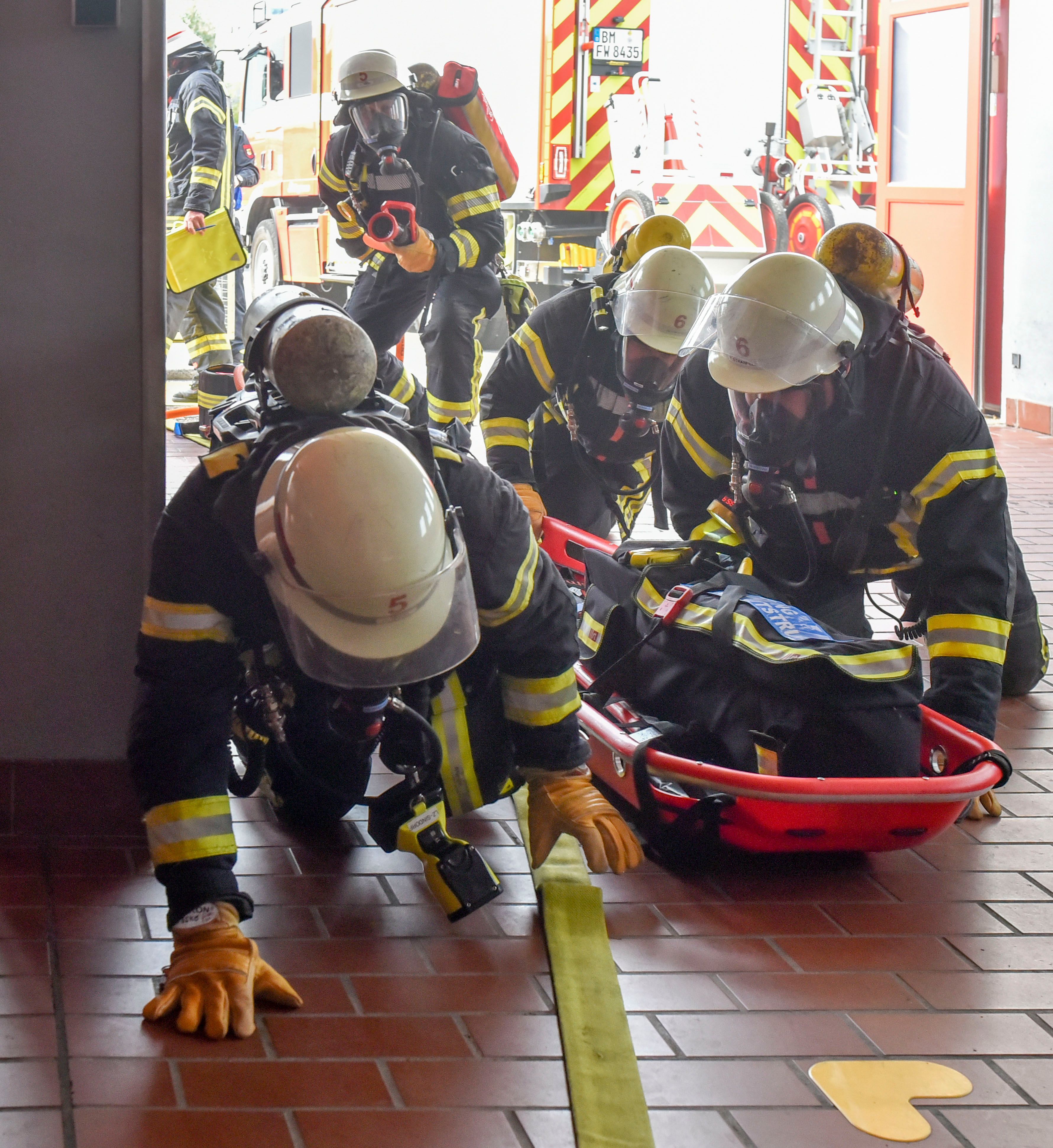 Das Bild zeigt Feuerwehrleute, die über  den Boden robben.