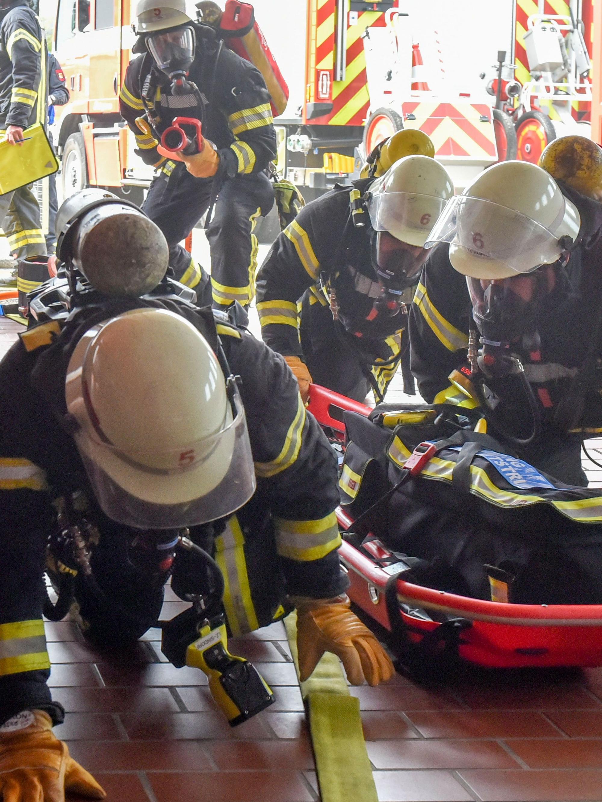 Das Bild zeigt Feuerwehrleute, die über den Boden robben.