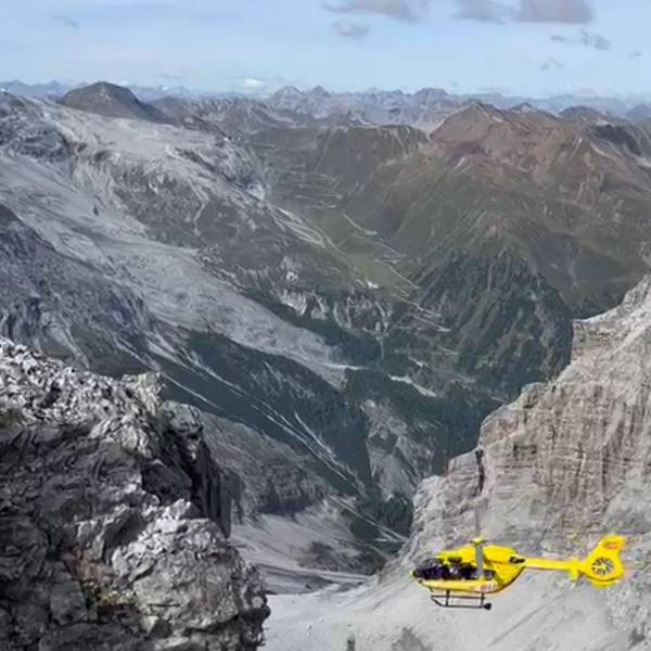 Ein Hubschrauber fliegt über ein Gebirge.