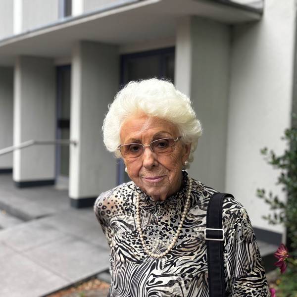 Auf dem Foto ist eine ältere Dame vor der Trauerhalle in Frechen zu sehen.