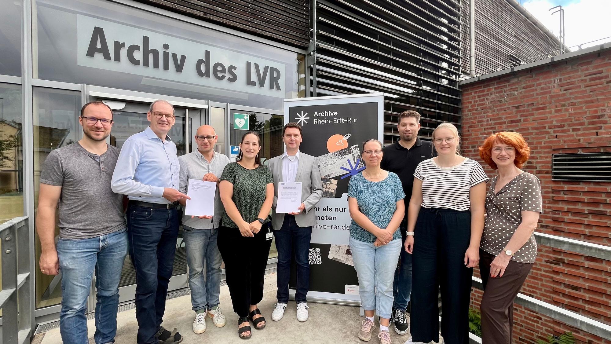 Frauen und Männer haben sich am Eingang des LVR-Archivs fürs Foto aufgestellt.