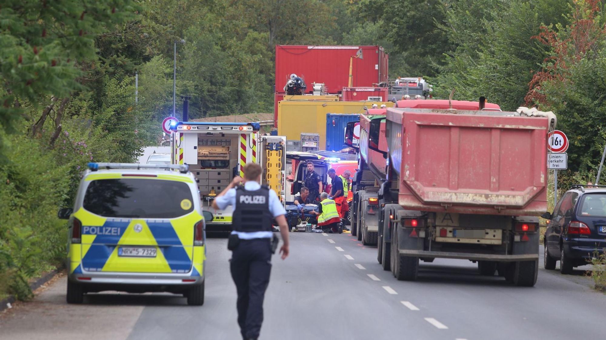 Mehrere Lastwagen neben einem Polizeifahrzeug und einem Rettungswagen.