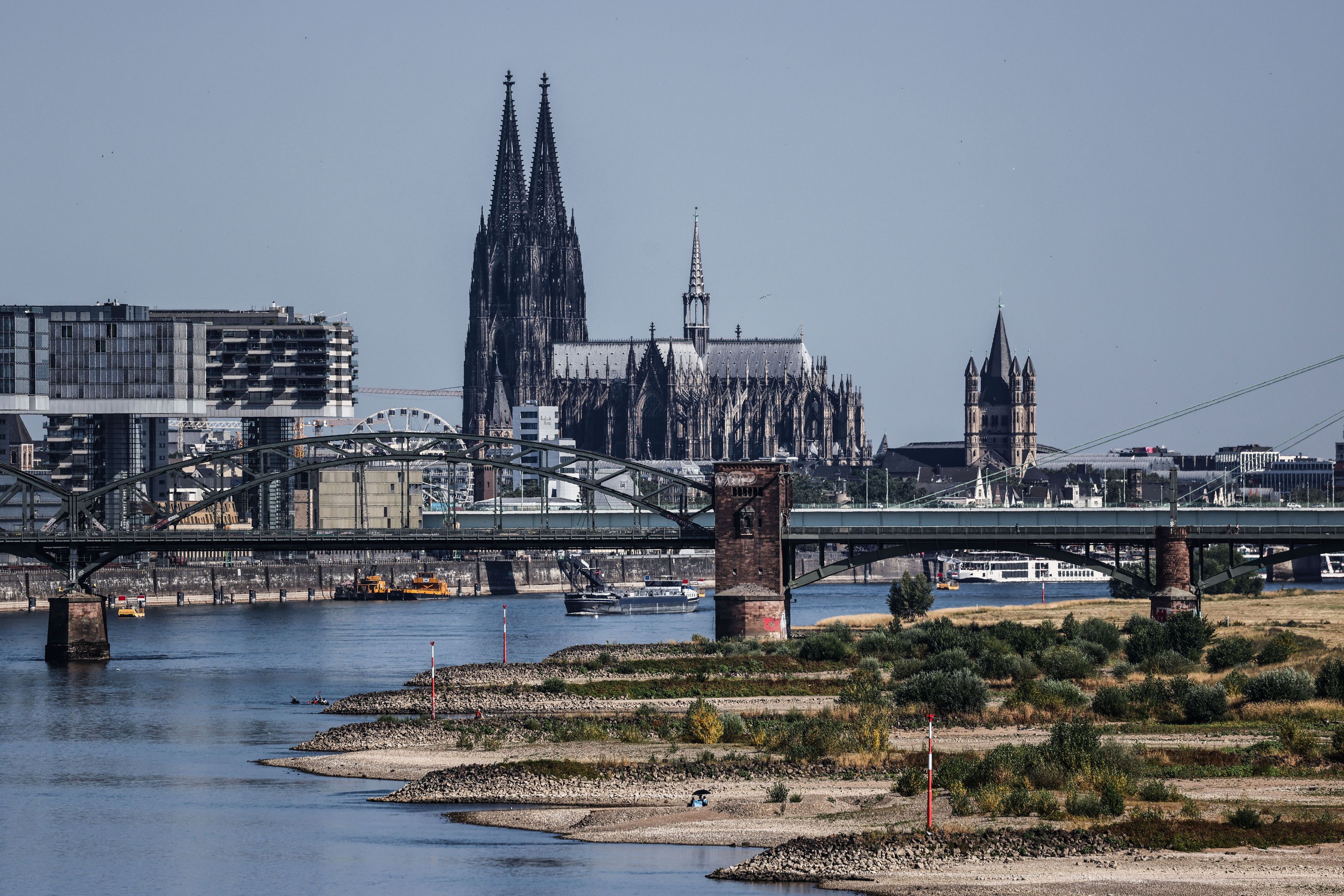 Binnenschiffe fahren bei niedrigen Pegelständen aufgrund von Trockenheit vor dem Kölner Dom auf dem Rhein.
