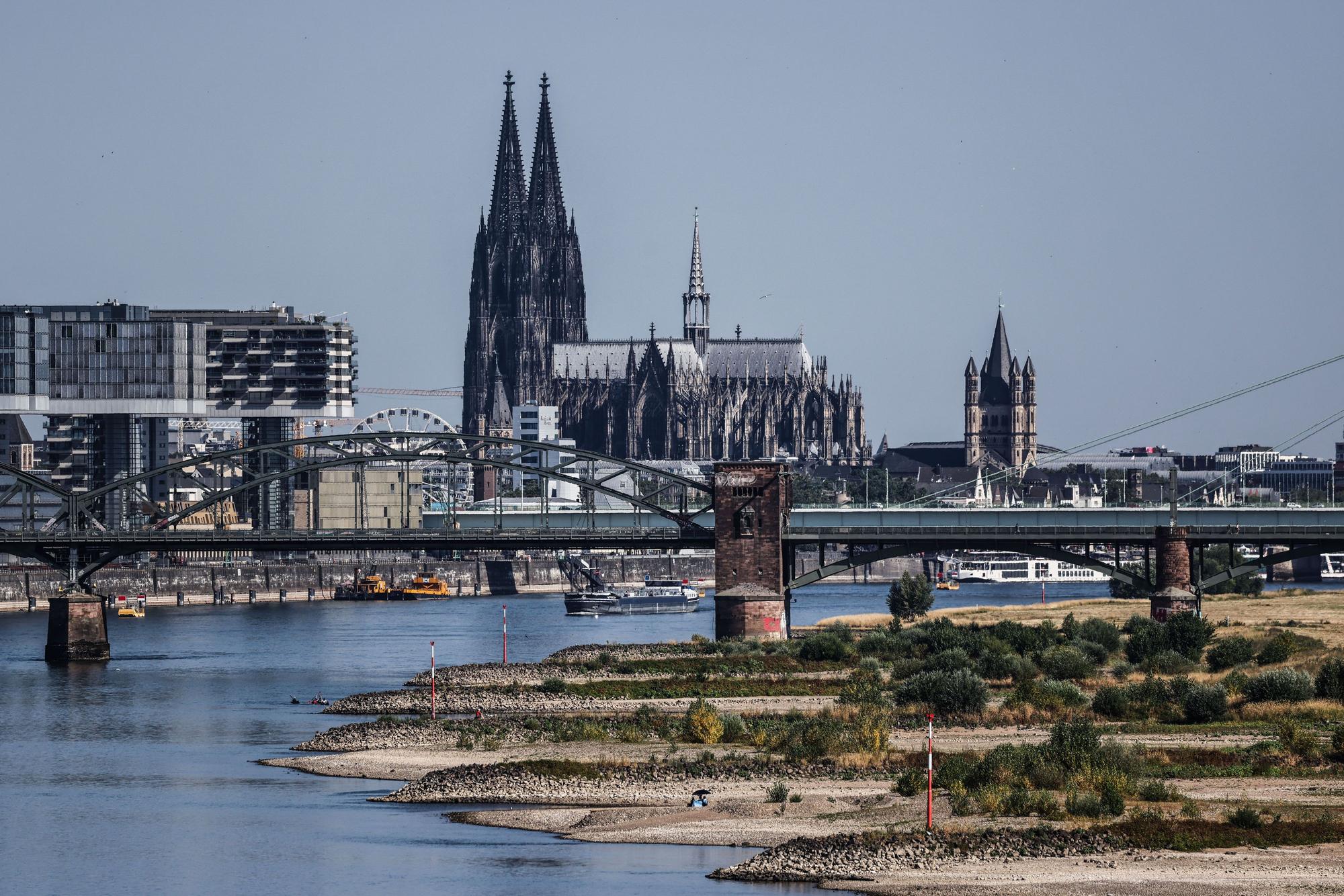 Binnenschiffe fahren bei niedrigen Pegelständen aufgrund von Trockenheit vor dem Kölner Dom auf dem Rhein.