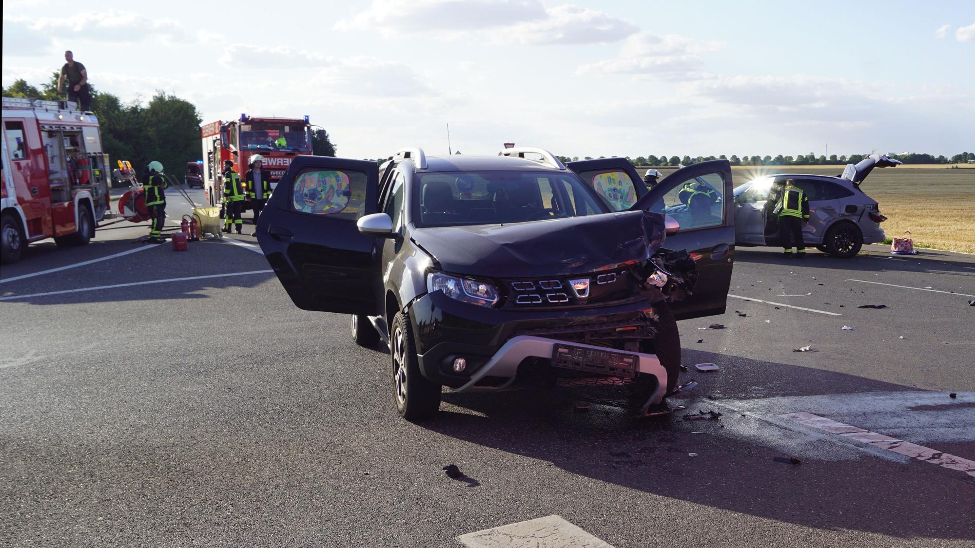Zwei beschädigte Autos und zwei Feuerwehrfahrzeuge stehen nach einem Unfall auf einer Straße in Zülpich.
