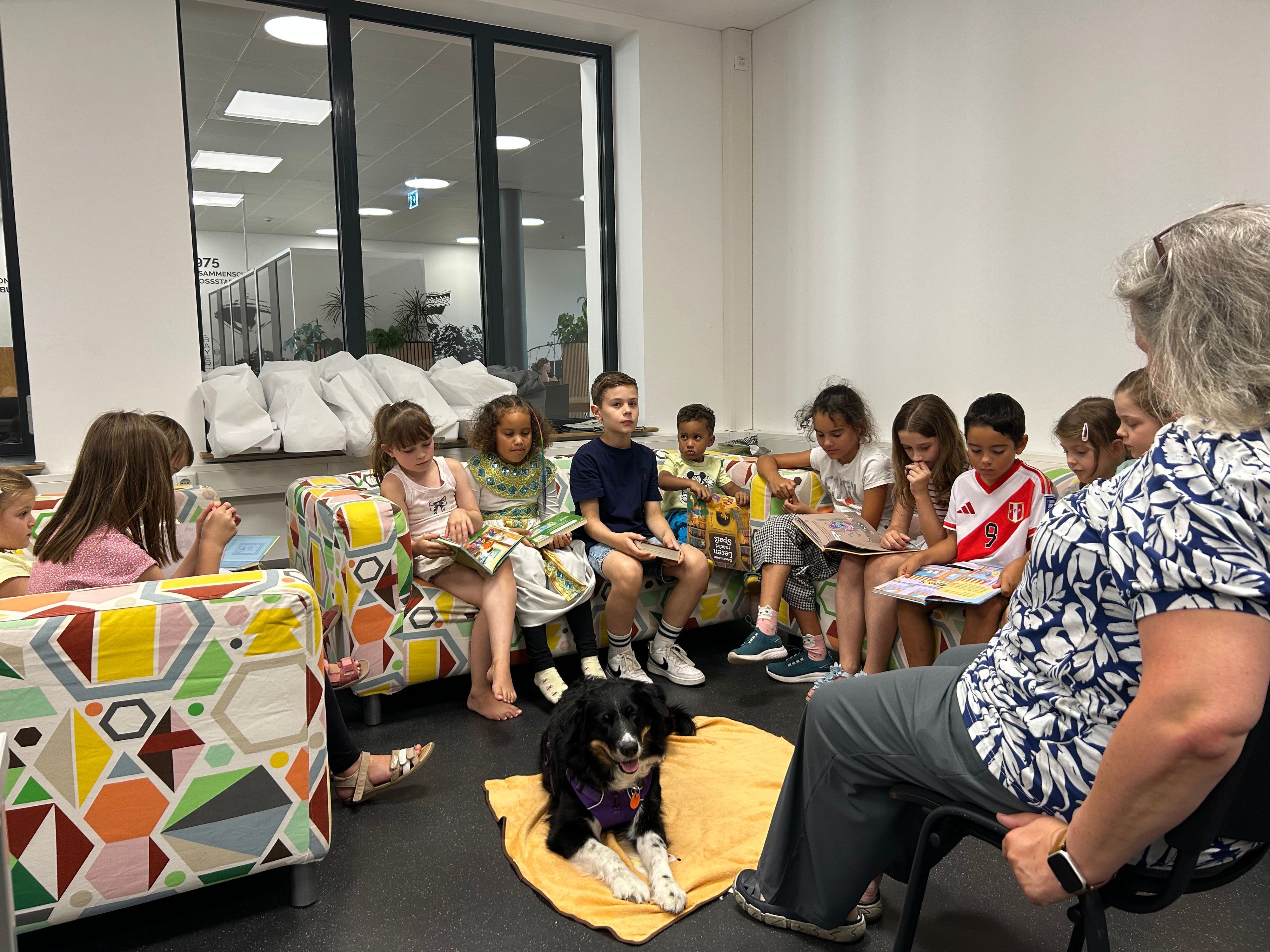 Therapiebegleithündin Lara hört Kindern beim Lesen zu.