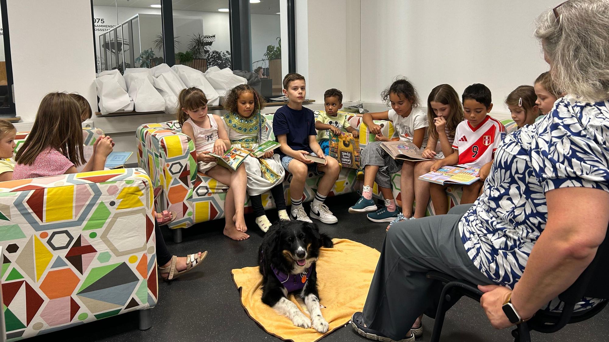 Therapiebegleithündin Lara hört Kindern beim Lesen zu.