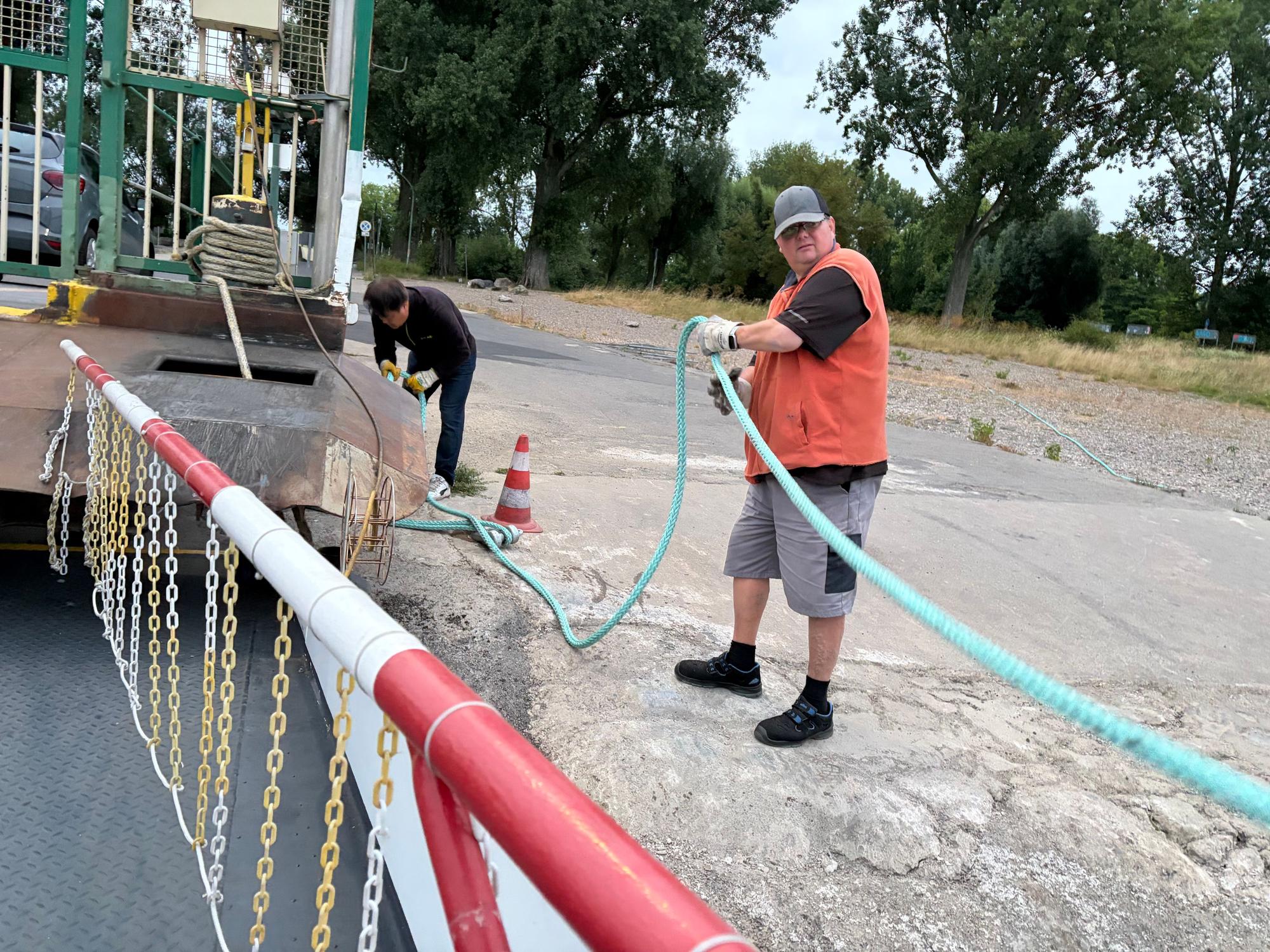 Leinen los: Matthias Müller und Tan Minh Nguyen arbeiten zusammen, bei Niedrigwasser ist die Fähre noch einmal speziell am Ufer vertäut.