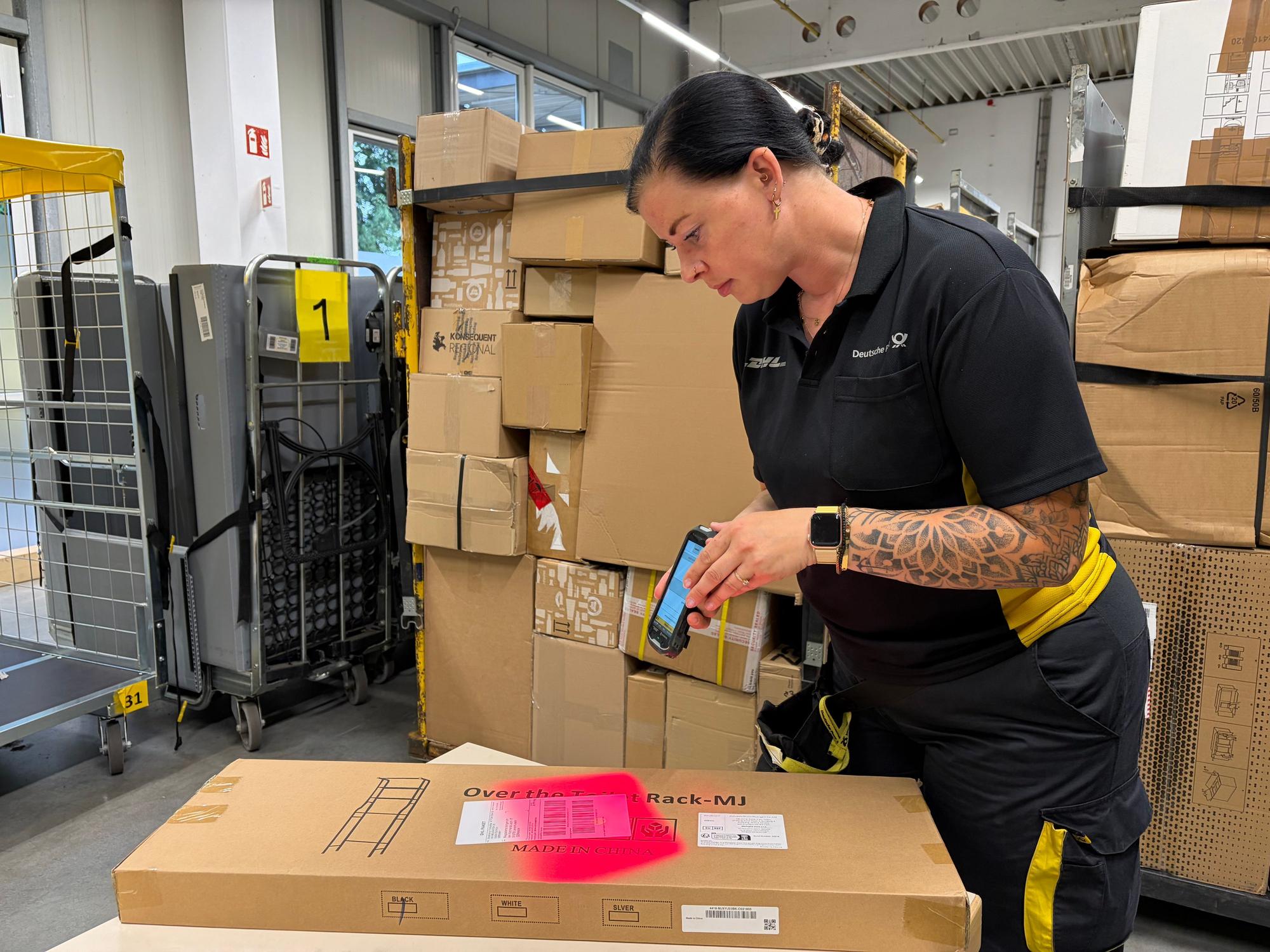 Verena Thomas zeigt, wie Pakete gescannt werden.