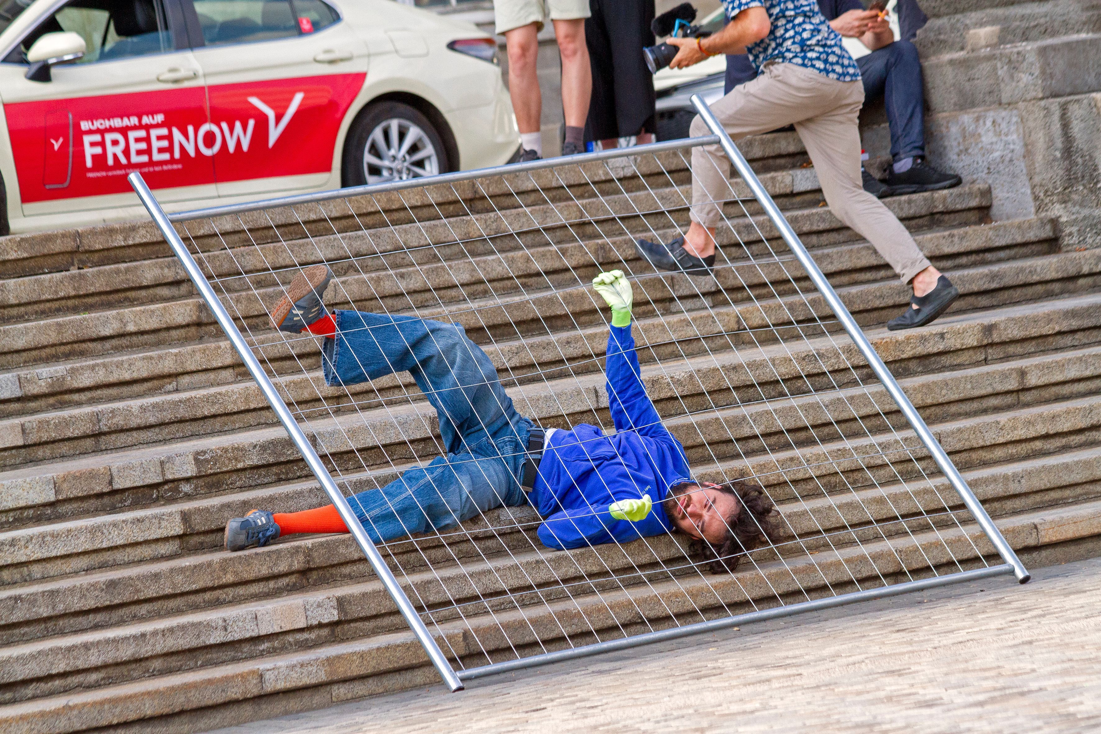 Performance-am-Deutzer-Bahnhof-Grenz-berschreitungen-unter-Gittern
