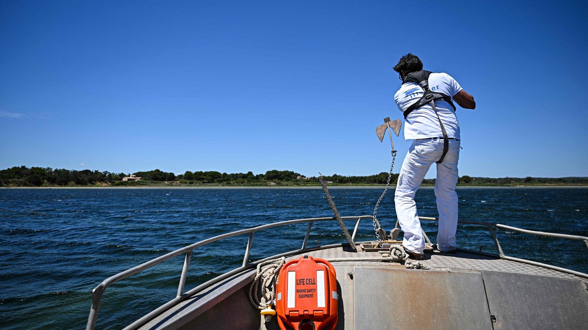 Ein Wissenschaftler lässt den Anker eines Forschungsbootes ins Wasser, bevor er die Gewässer des Étang de Thau bei Sète in Südfrankreich untersucht.