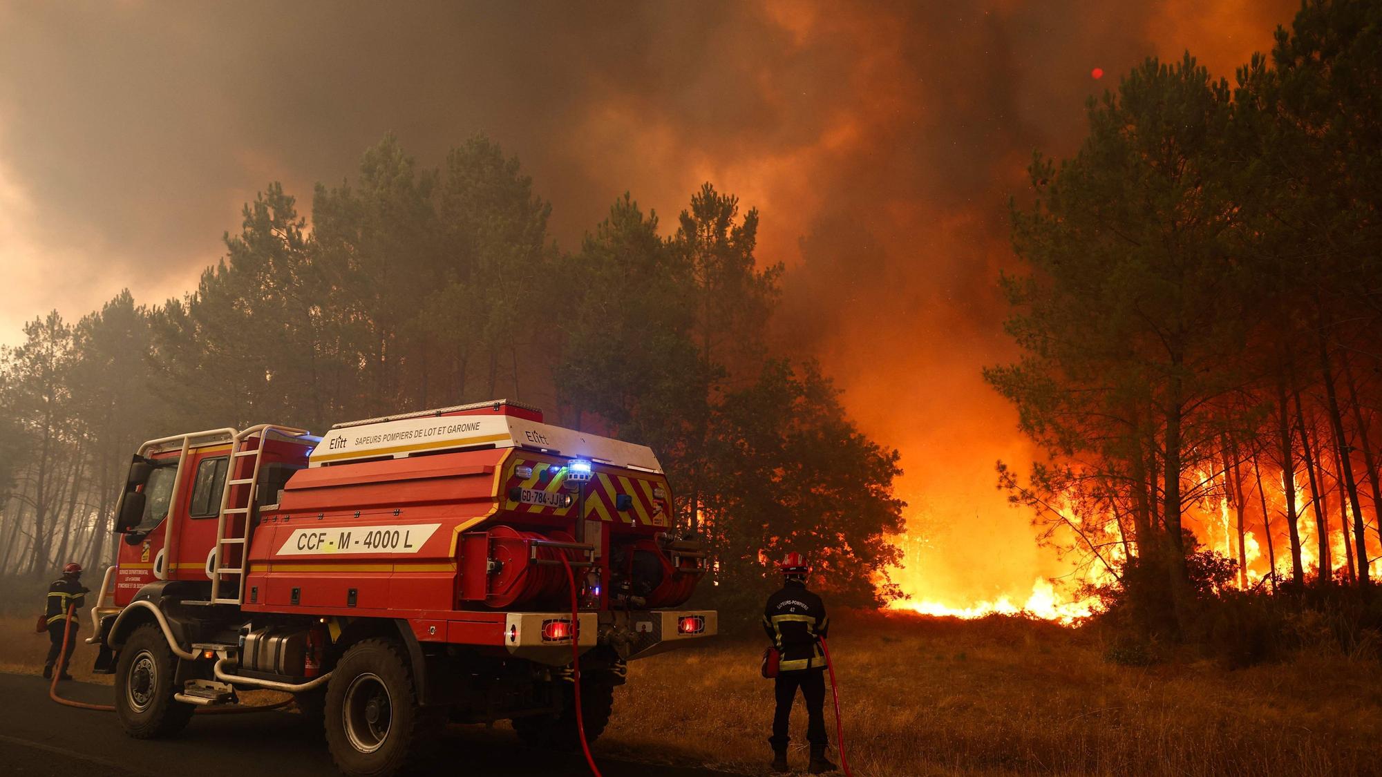 Feuerwehrleute versuchen in der Nähe von Le Porge im Südwesten Frankreichs mit einem Waldbrandlöschfahrzeug, die brennenden Bäume zu löschen.