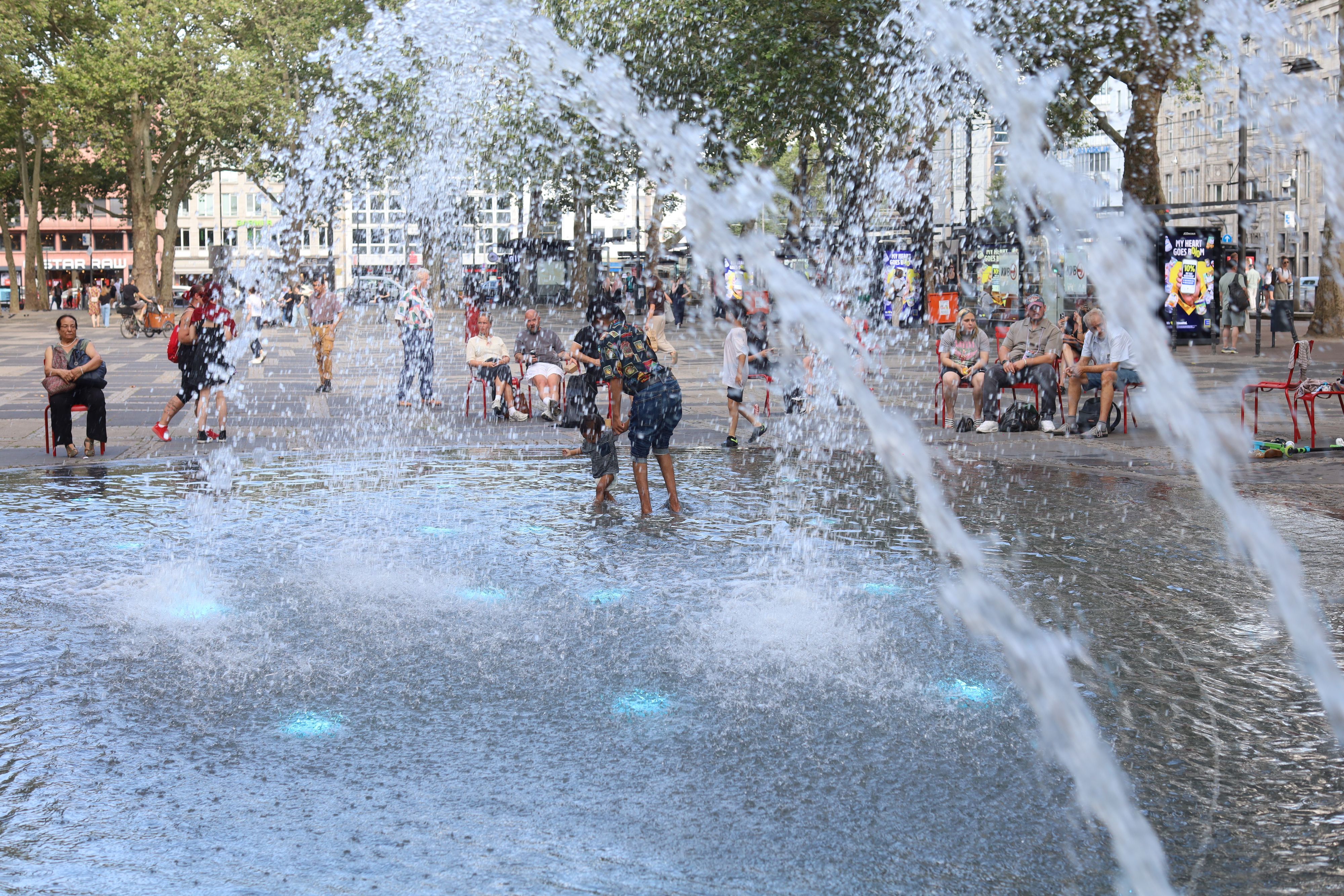 Der Brunnen auf dem Neumarkt sorgt bei den Temperaturen für eine Abkühlung.