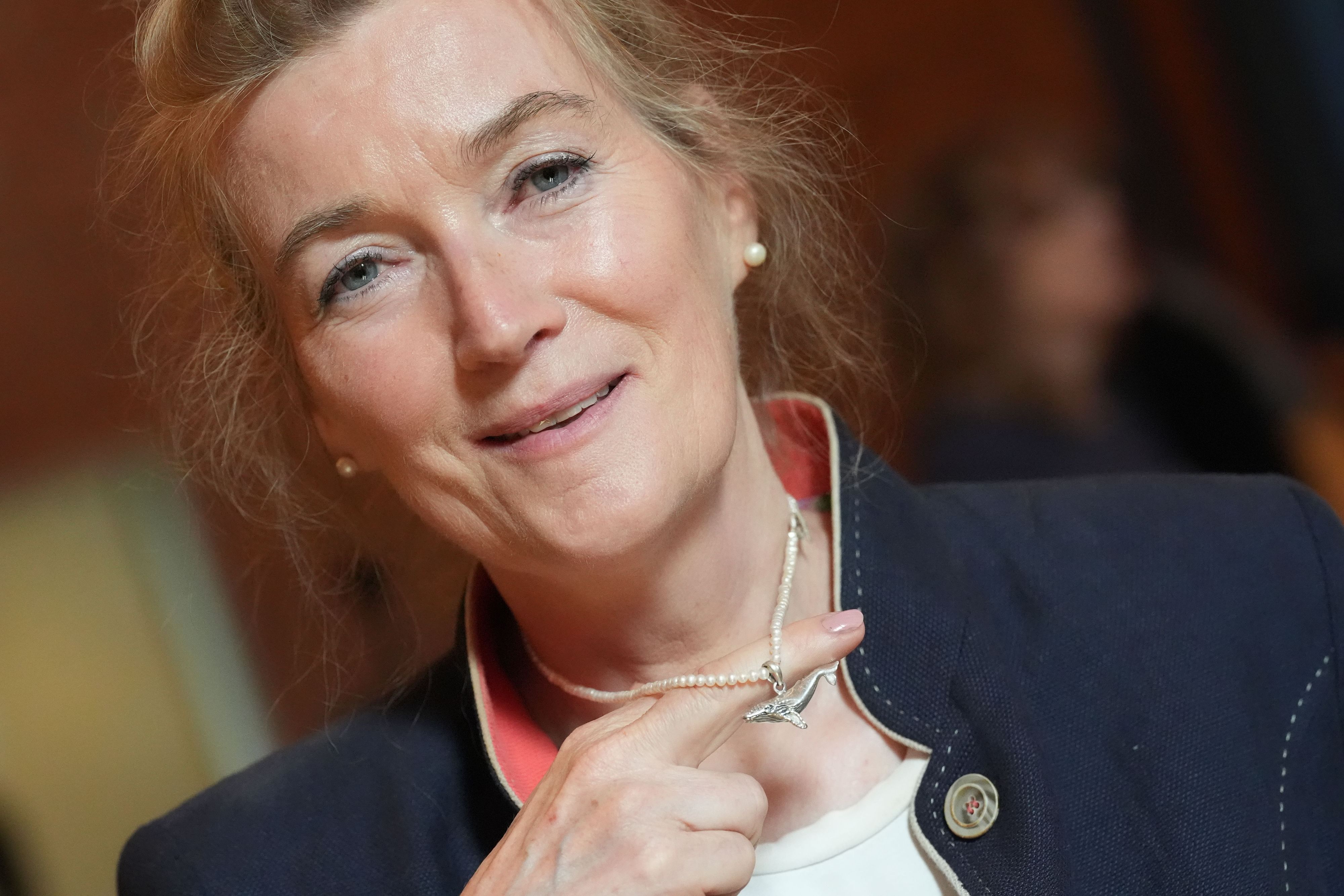 Tierärztin Kirsten Tönnies hält nach einer Pressekonferenz im Hamburg-Haus Eimsbüttel zum in der Ostsee gestrandeten Buckelwal Timmy ihren Buckelwal-Anhänger an der Halskette hoch.