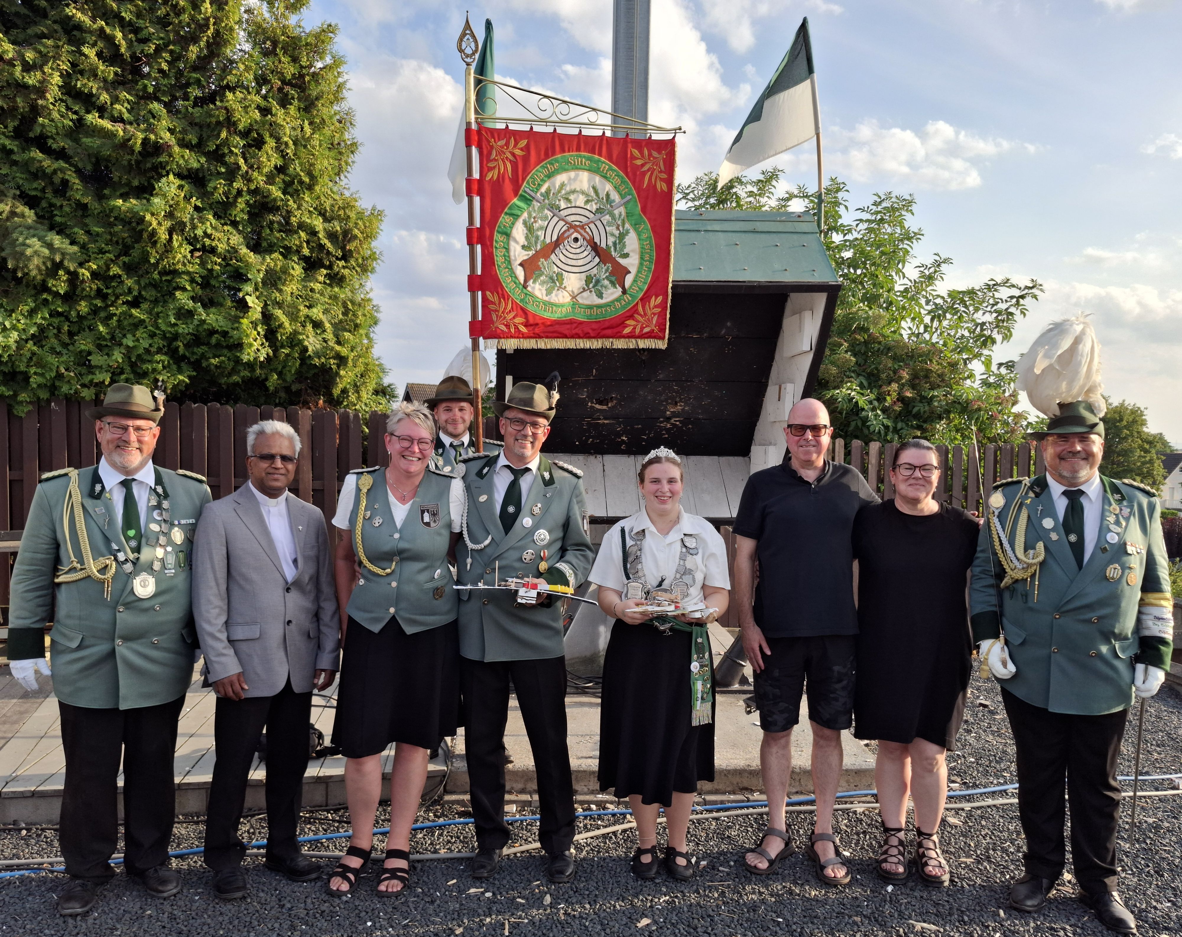 Schützen mit und ohne Uniform haben sich zum Gruppenbild aufgestellt.