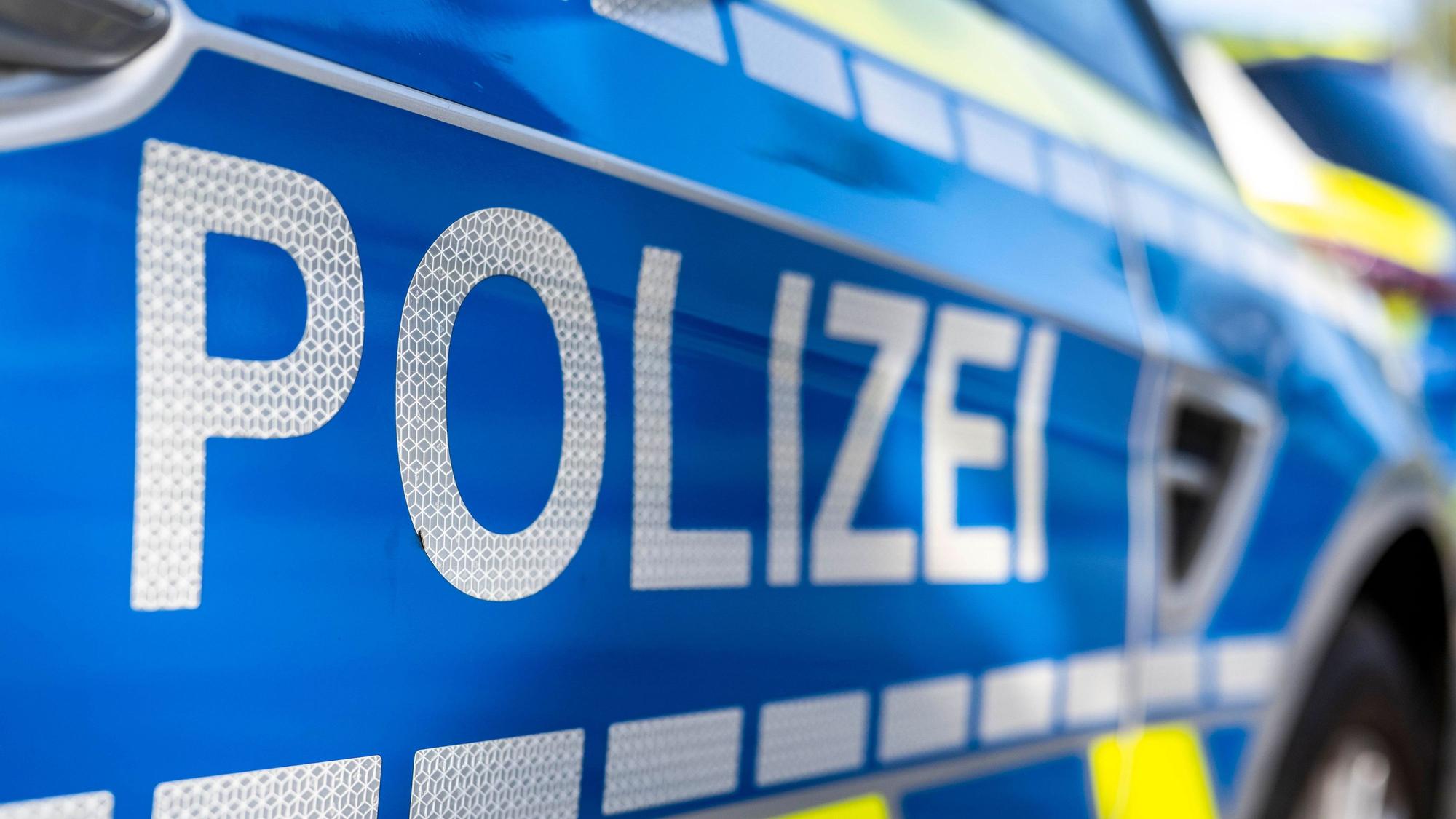 An der Tür von einem Streifenwagen steht der Schriftzug „Polizei“.