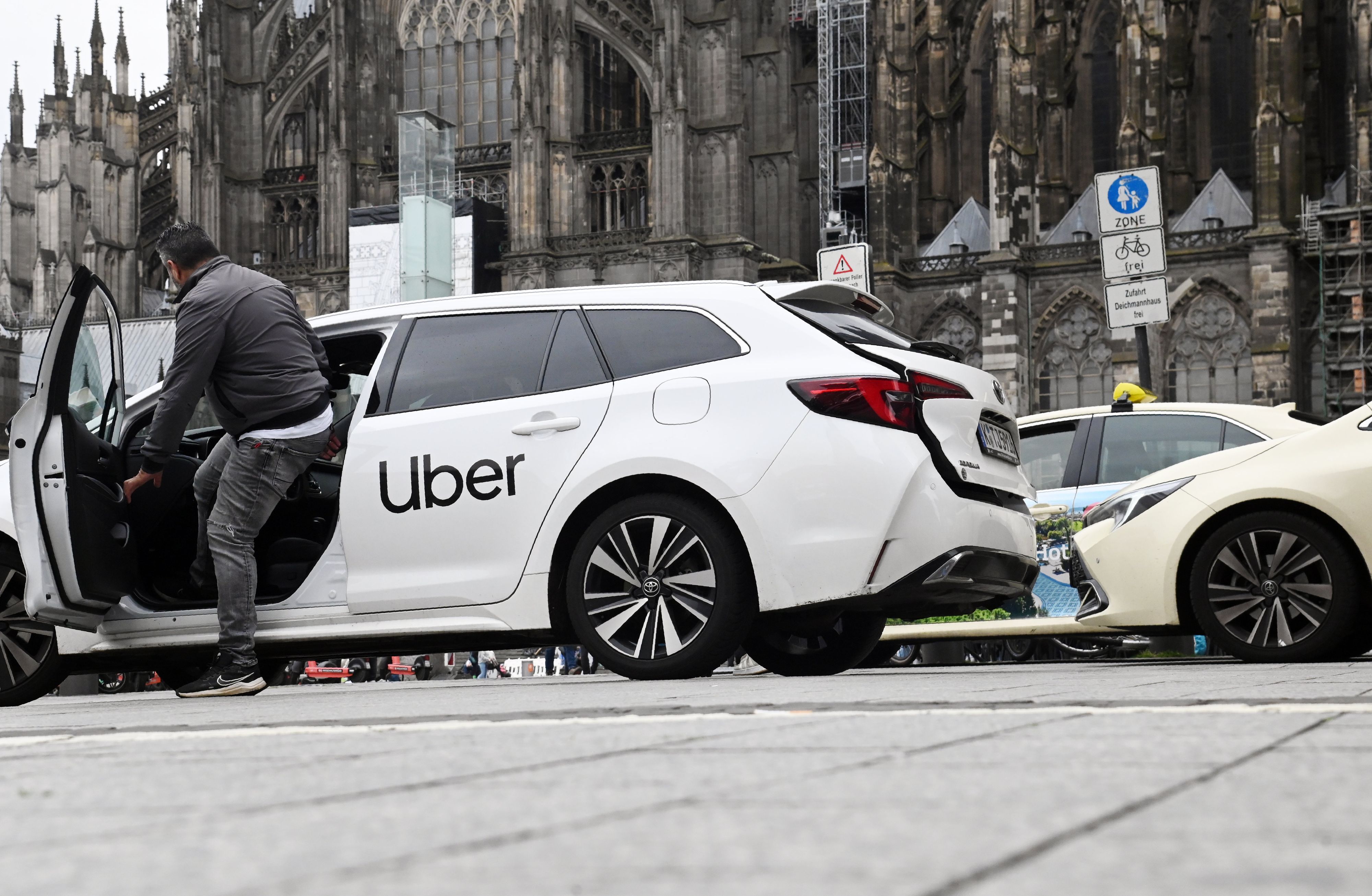 Ein Uber Fahrzeug am Taxistand vor dem Hauptbahnhof und Dom.