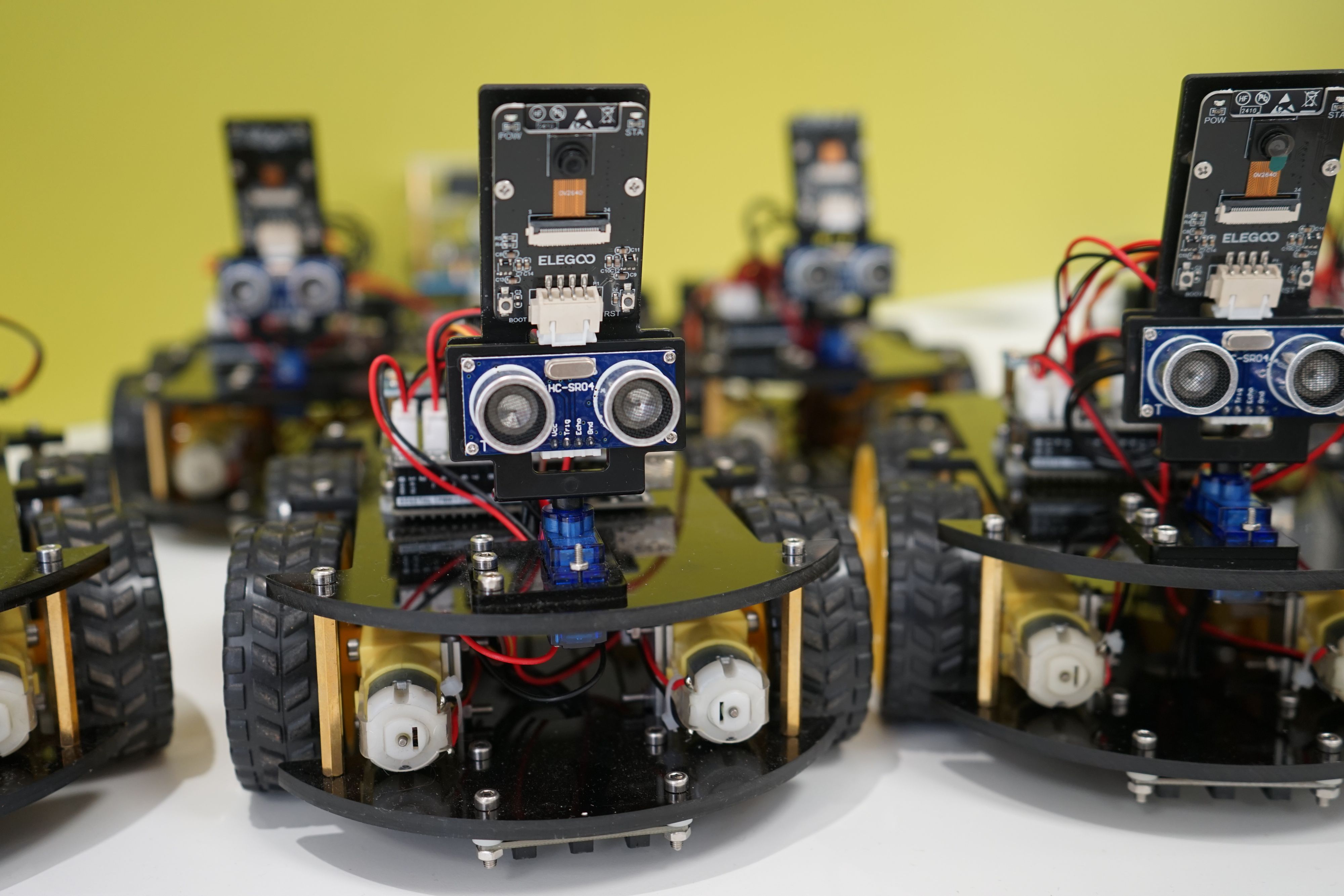 Roboter auf Rädern und mit Kameras stehen in einer Reihe.