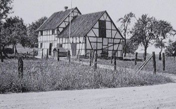 Schwarz-weiß Aufnahme des alten Fachwerkhauses auf dem Hof.