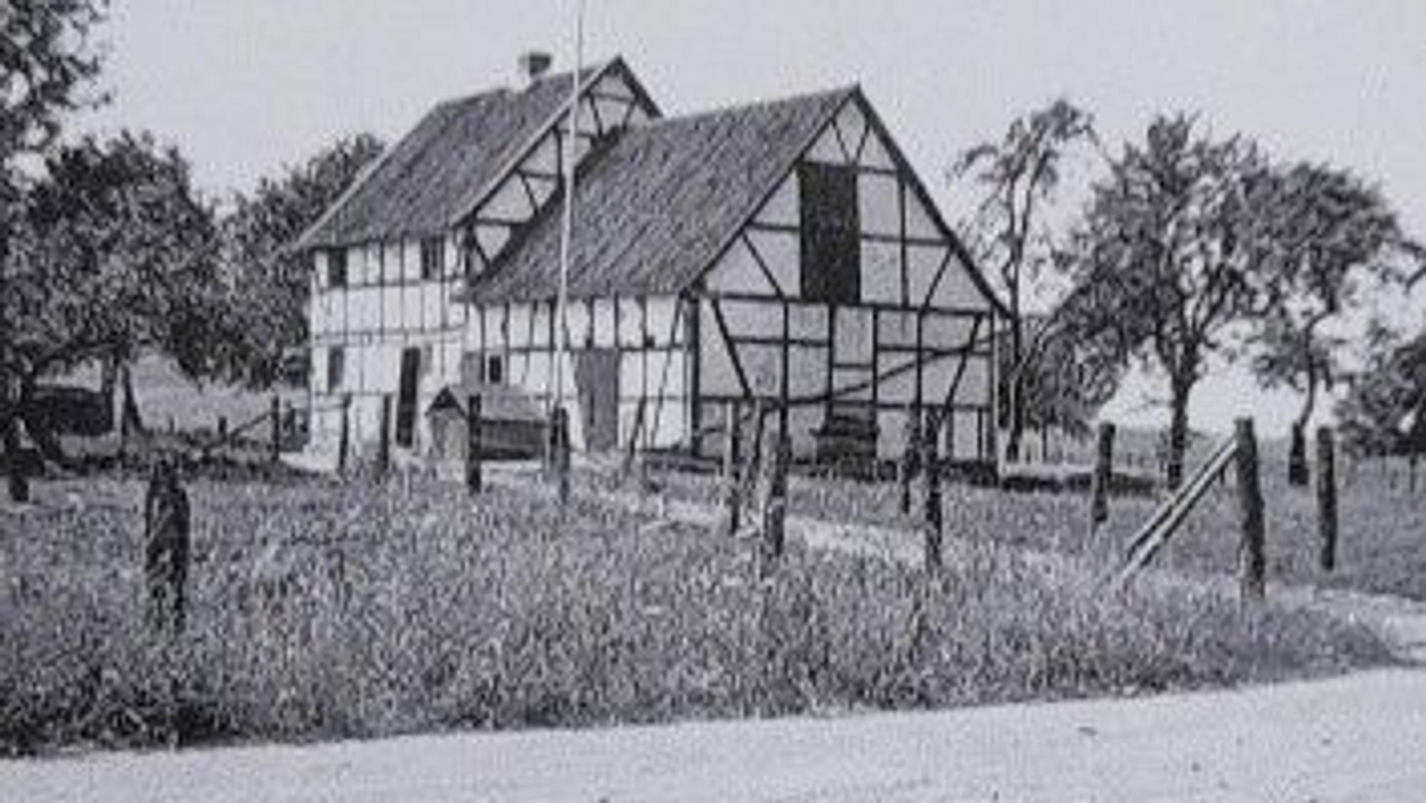 Schwarz-weiß Aufnahme des alten Fachwerkhauses auf dem Hof.
