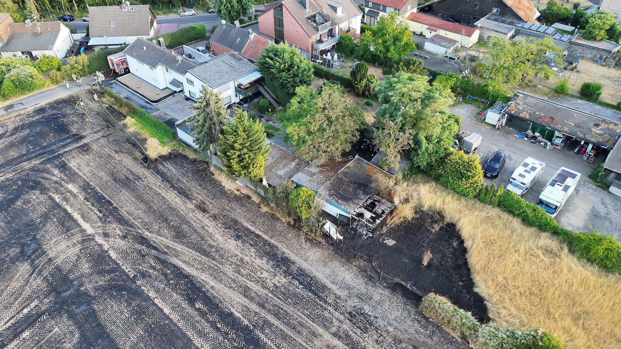 Die von der Feuerwehr Köln zur Verfügung gestellte Aufnahme zeigt Einsatzkräfte der Feuerwehr bei einem Bodenfeuer. Bei einem Feldbrand in Köln sind drei Menschen verletzt worden.