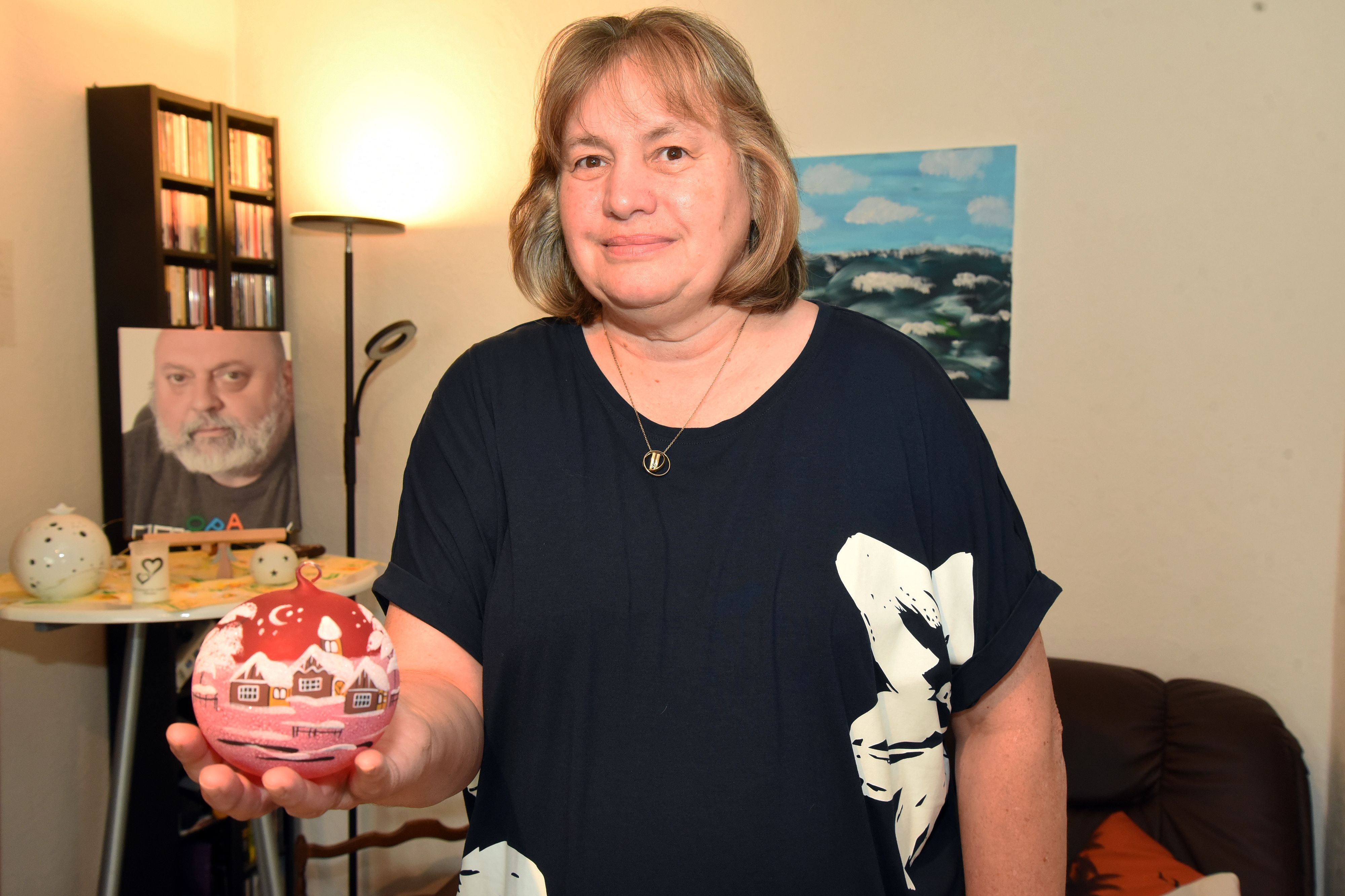 Eine Frau zeigt eine Christbaumkugel.