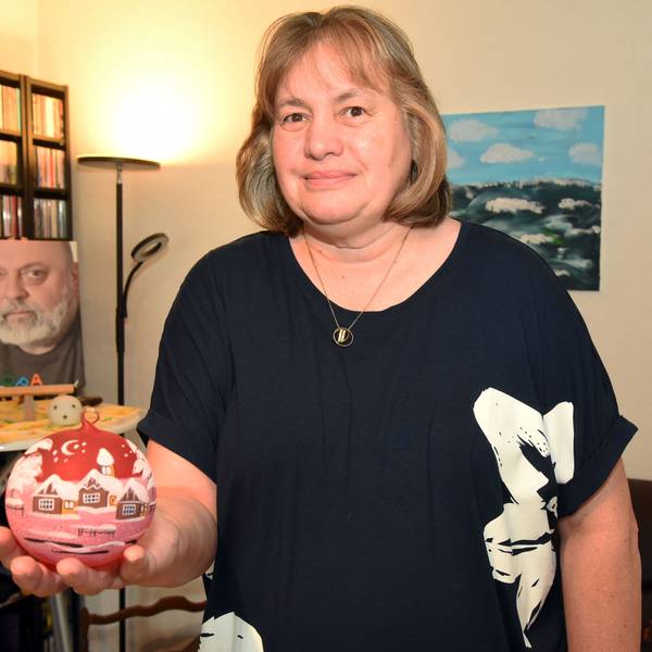 Eine Frau zeigt eine Christbaumkugel.