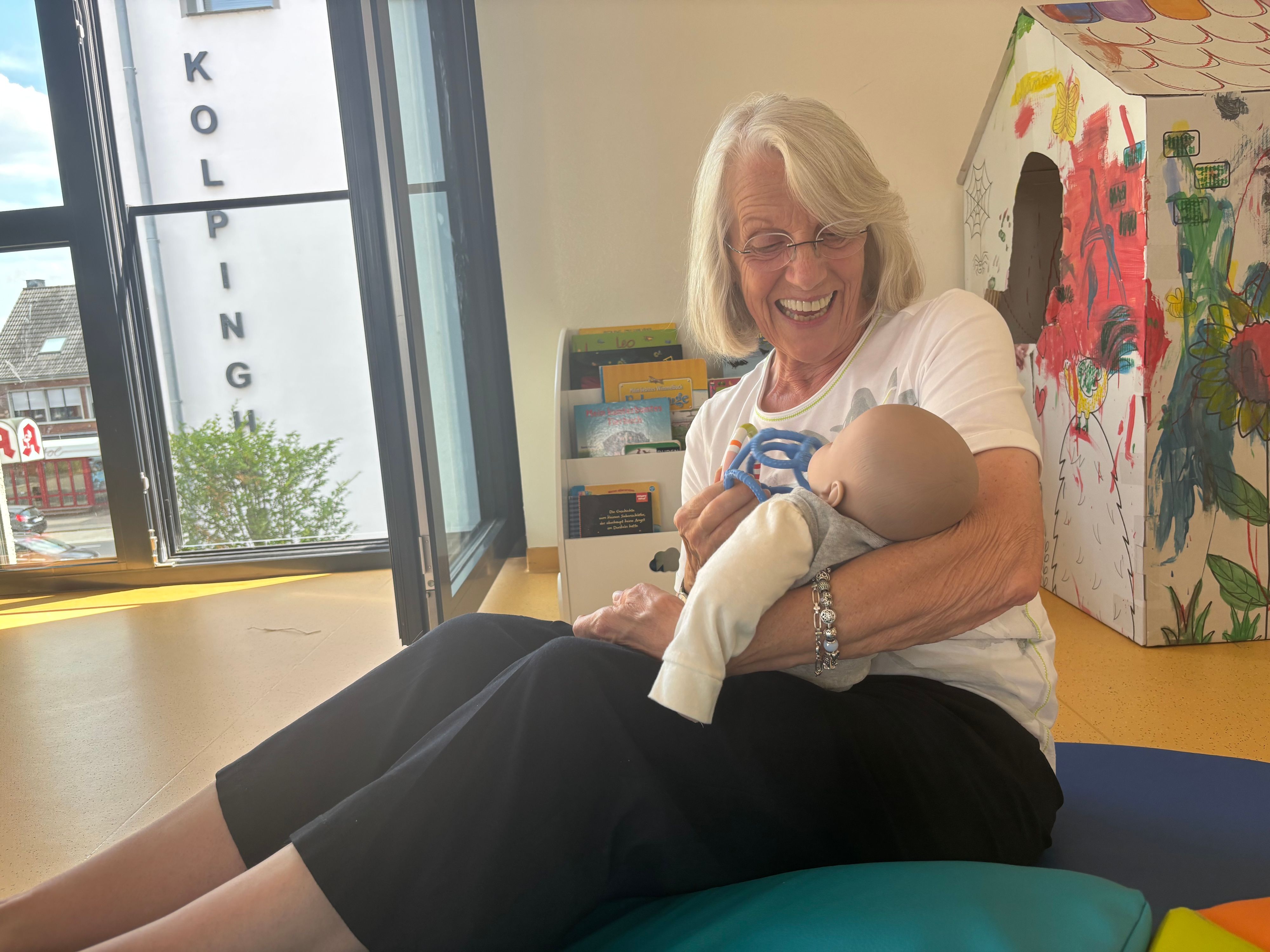 Das Foto zeigt eine Frau, die ein Baby auf dem Arm hält.