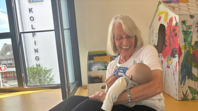 Das Foto zeigt eine Frau, die ein Baby auf dem Arm hält.