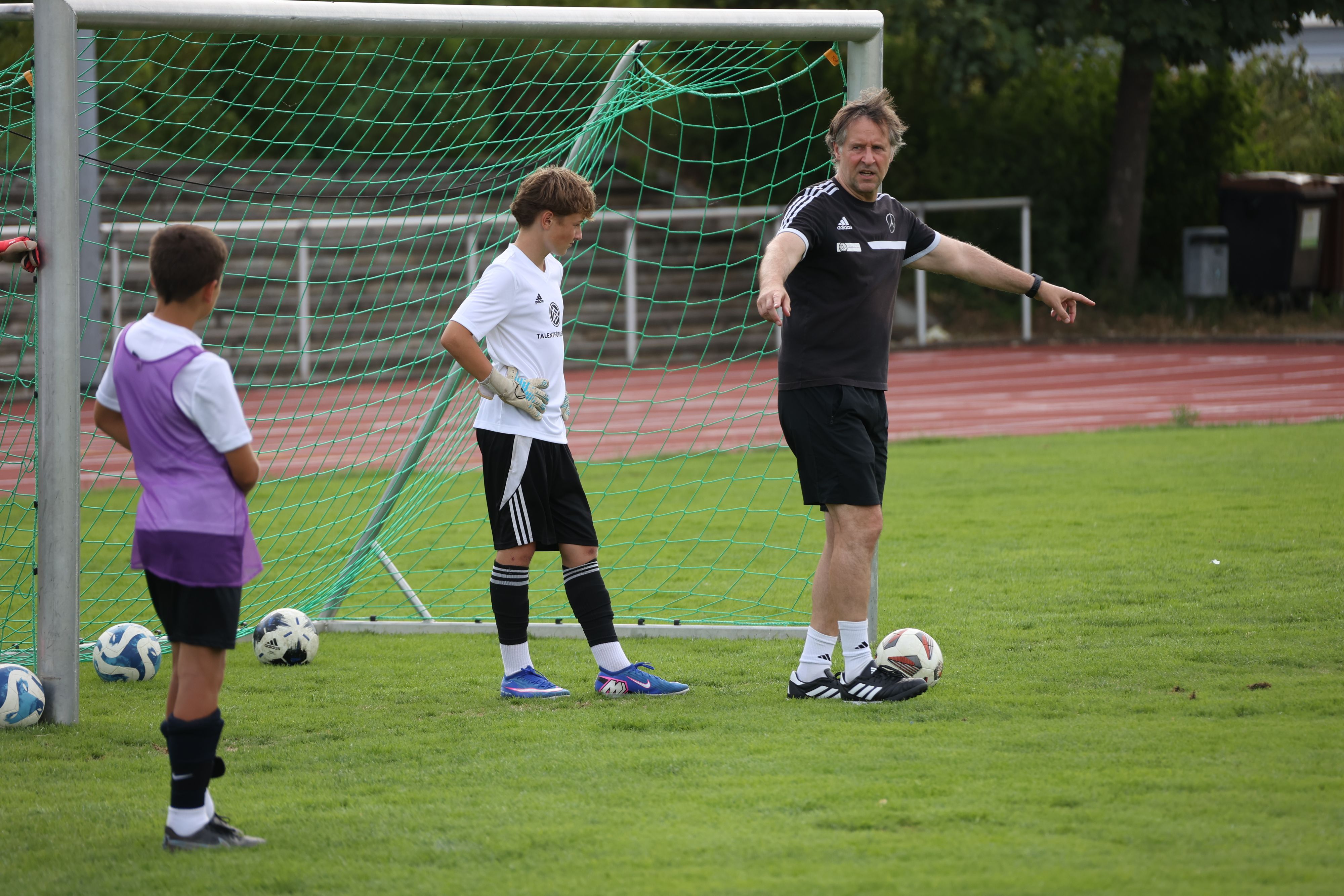 Das Bild zeigt den Jugendtrainer während einer Übung auf dem Fußballplatz.