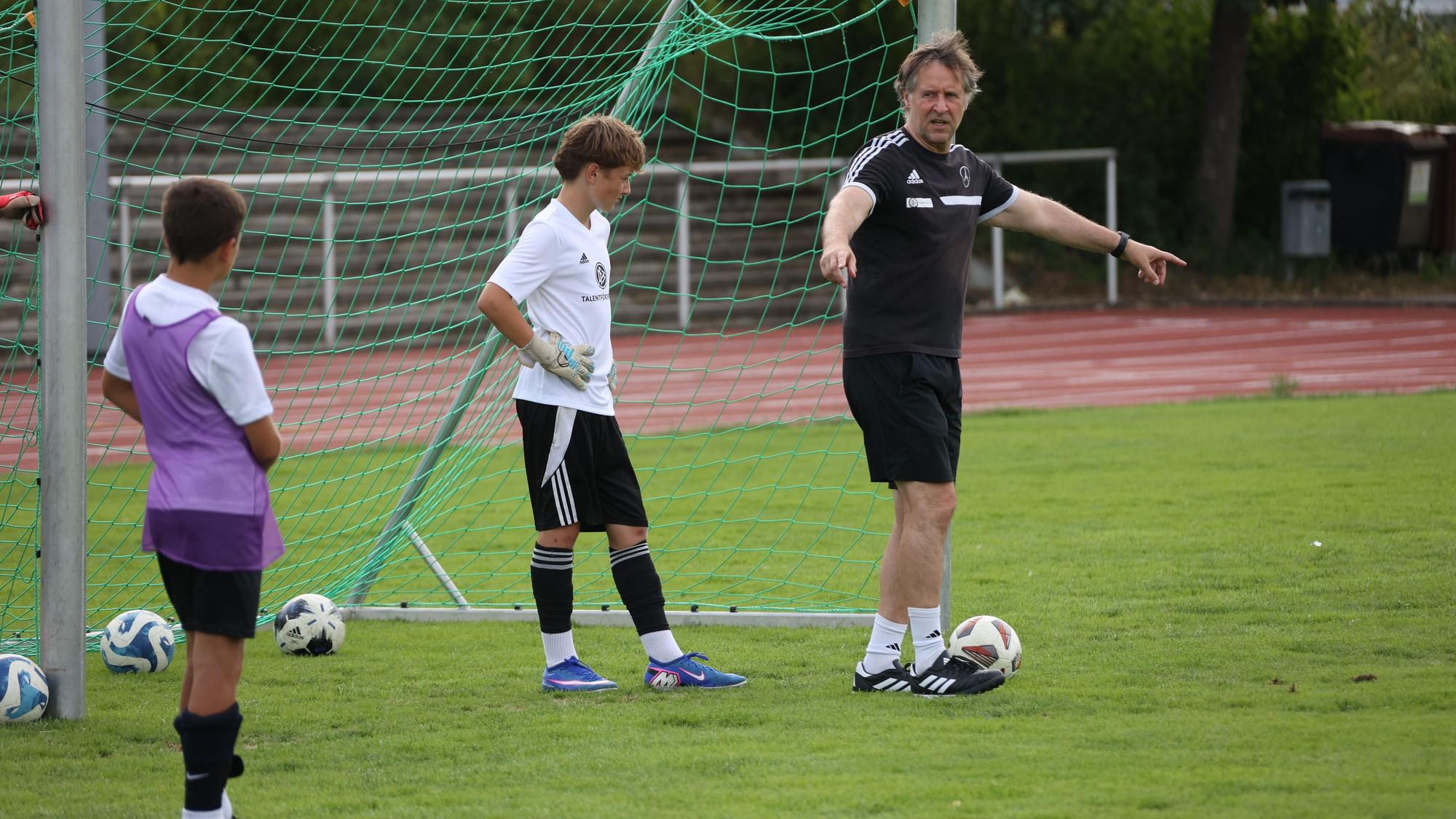 Das Bild zeigt den Jugendtrainer während einer Übung auf dem Fußballplatz.