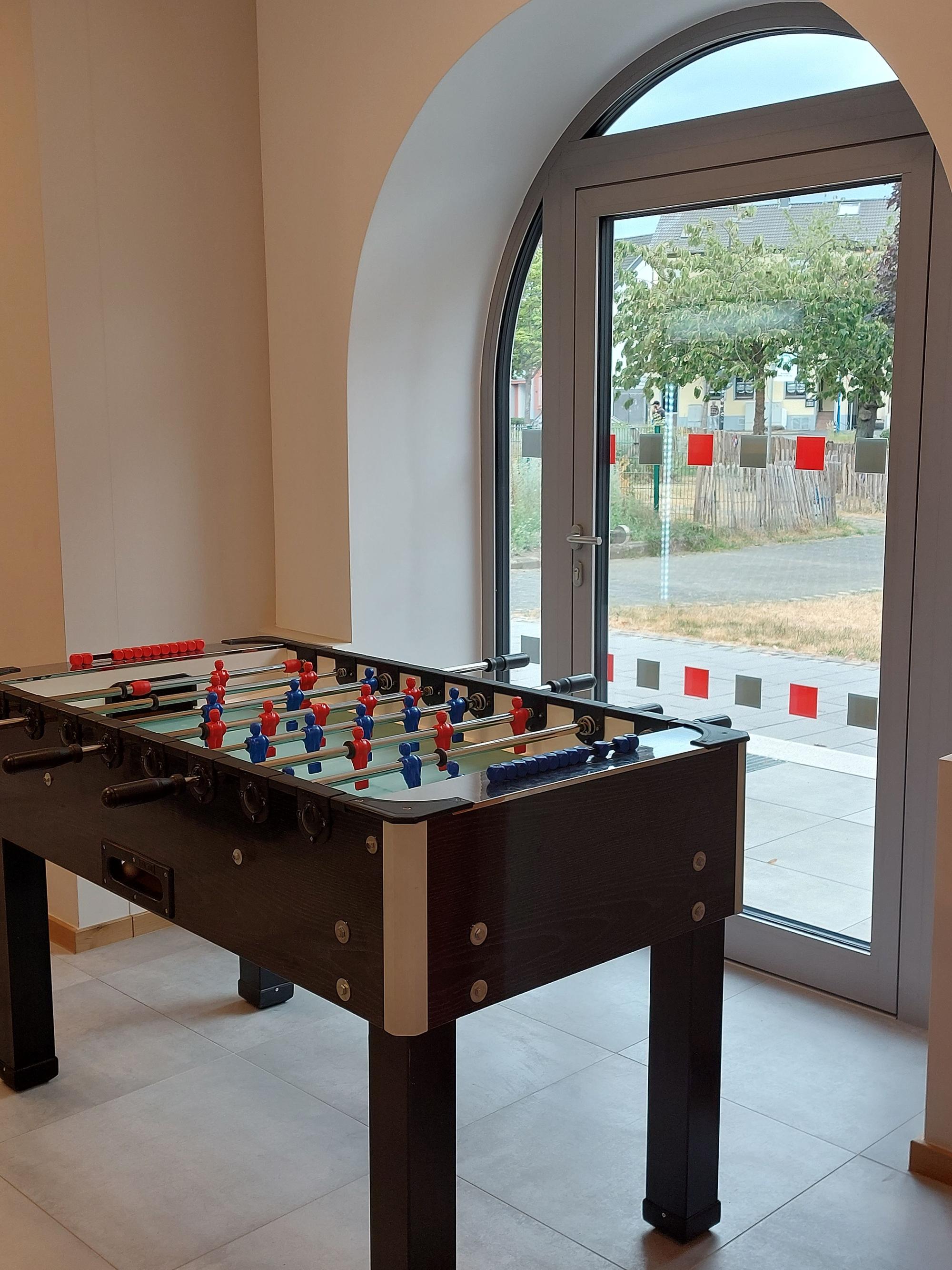 Ein Tischfußball vor einer Glastür.
