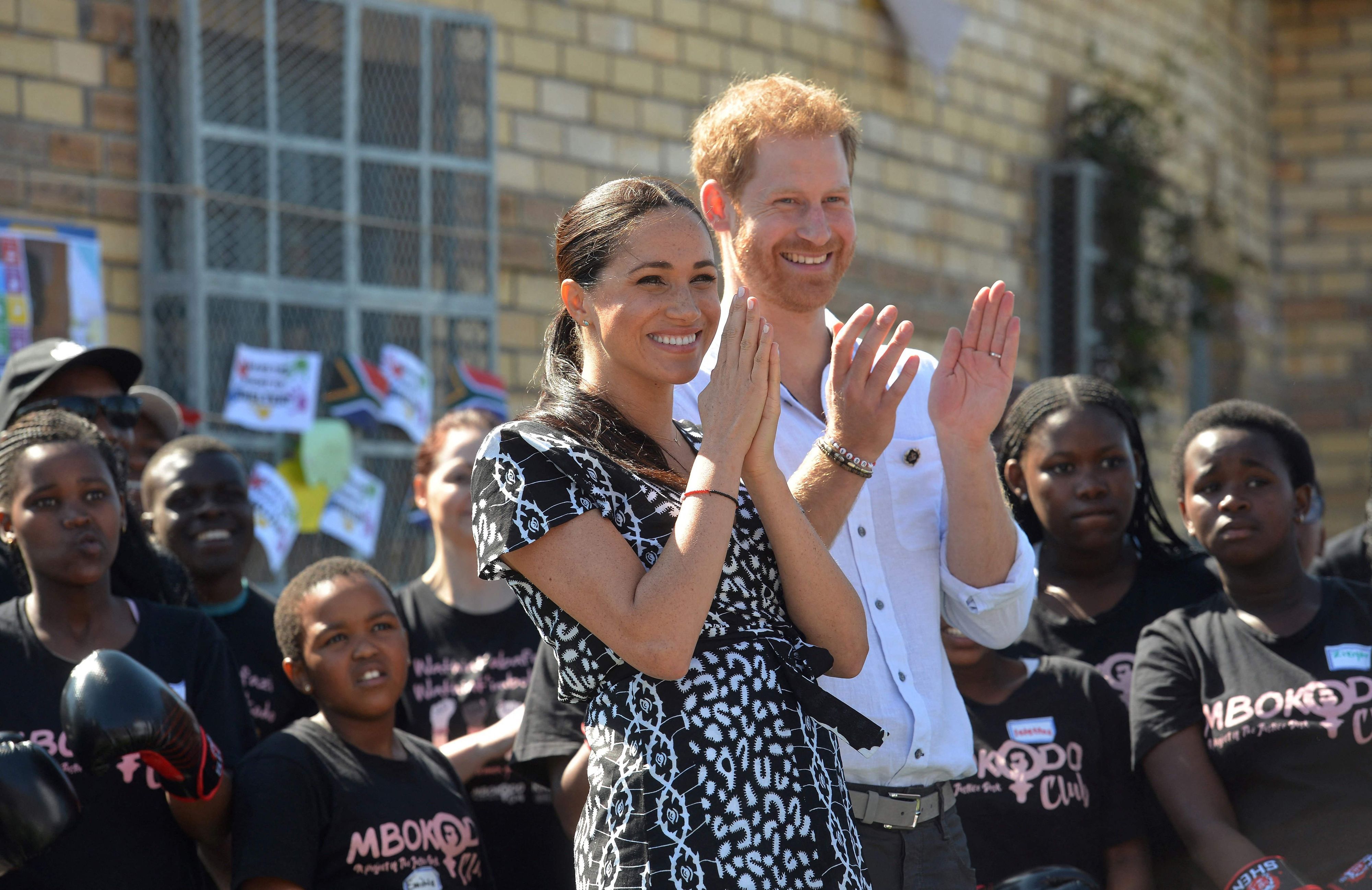 Prinz Harry und Herzogin Meghan klatschen.