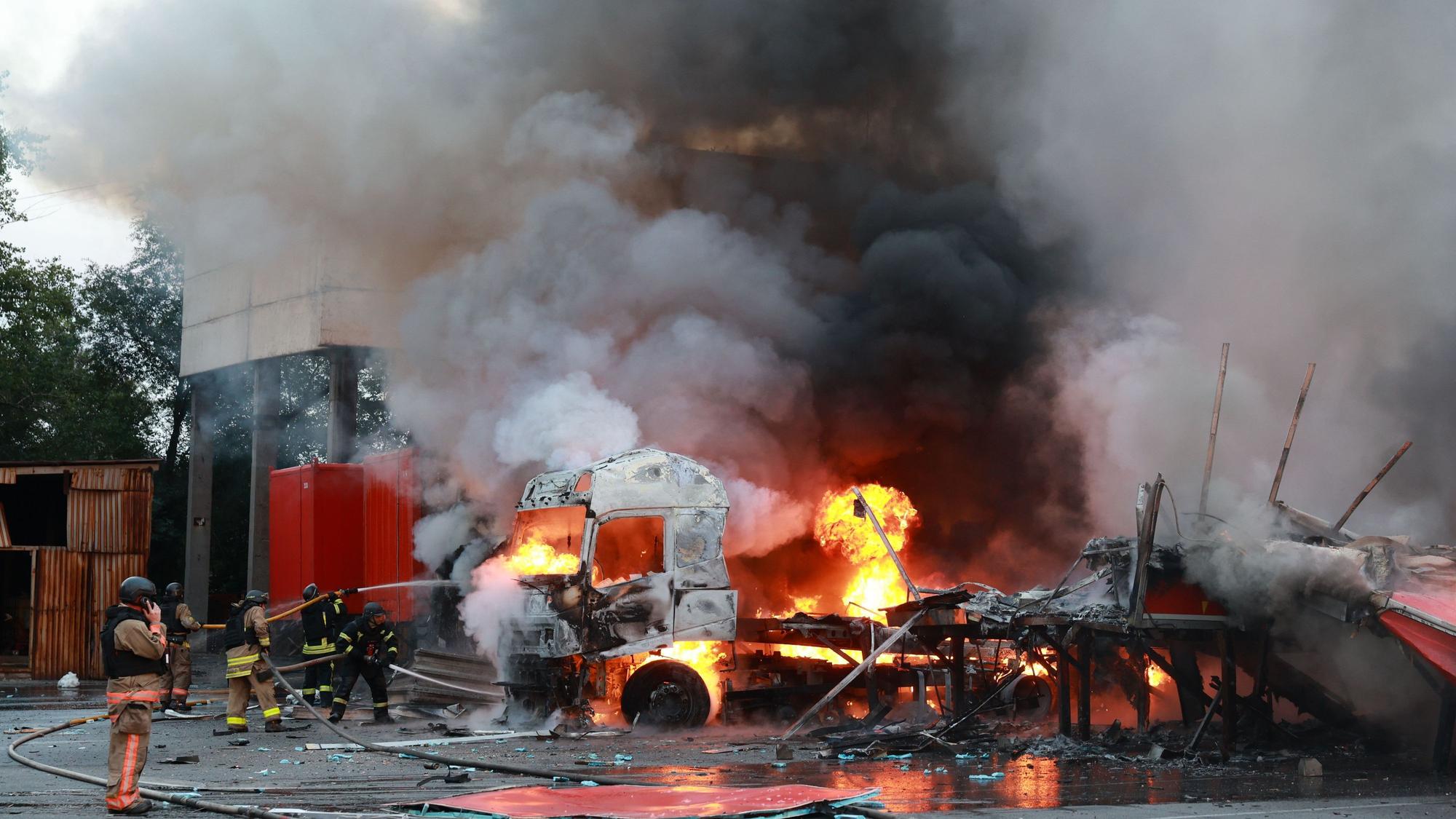 Ukraine, Saporischschja: Rettungskräfte versuchen, einen Brand in einem Postsortierzentrum zu löschen, nachdem dort eine russische Gleitbombe eingeschlagen ist.