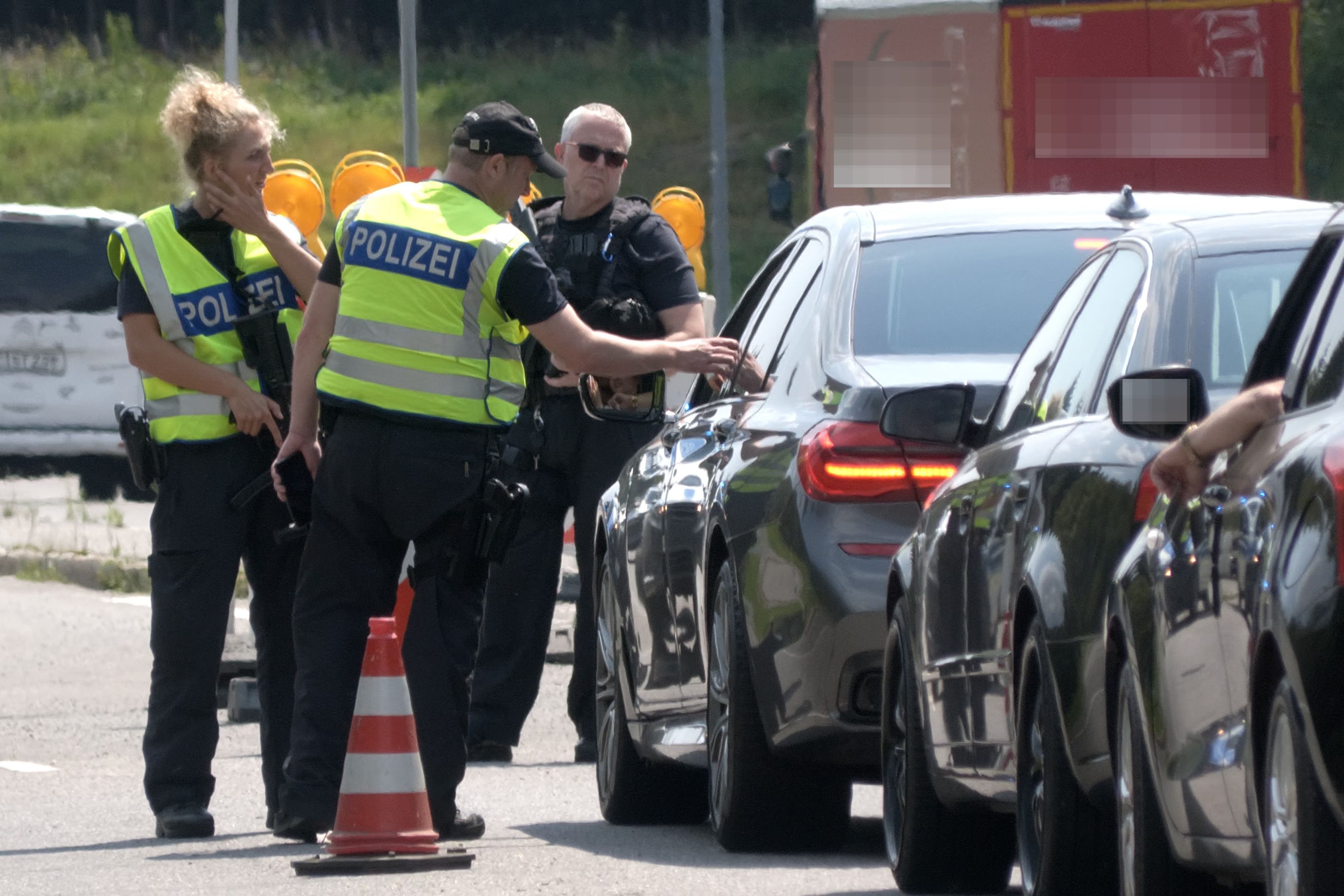 Polizisten kontrollieren am Grenzübergang nach Tschechien die Fahrzeuge. Nach dem Tatverdächtigen für den mutmaßlichen Terroranschlag am Rande des Christopher Street Day (CSD) in Berlin wird bundesweit gefahndet.