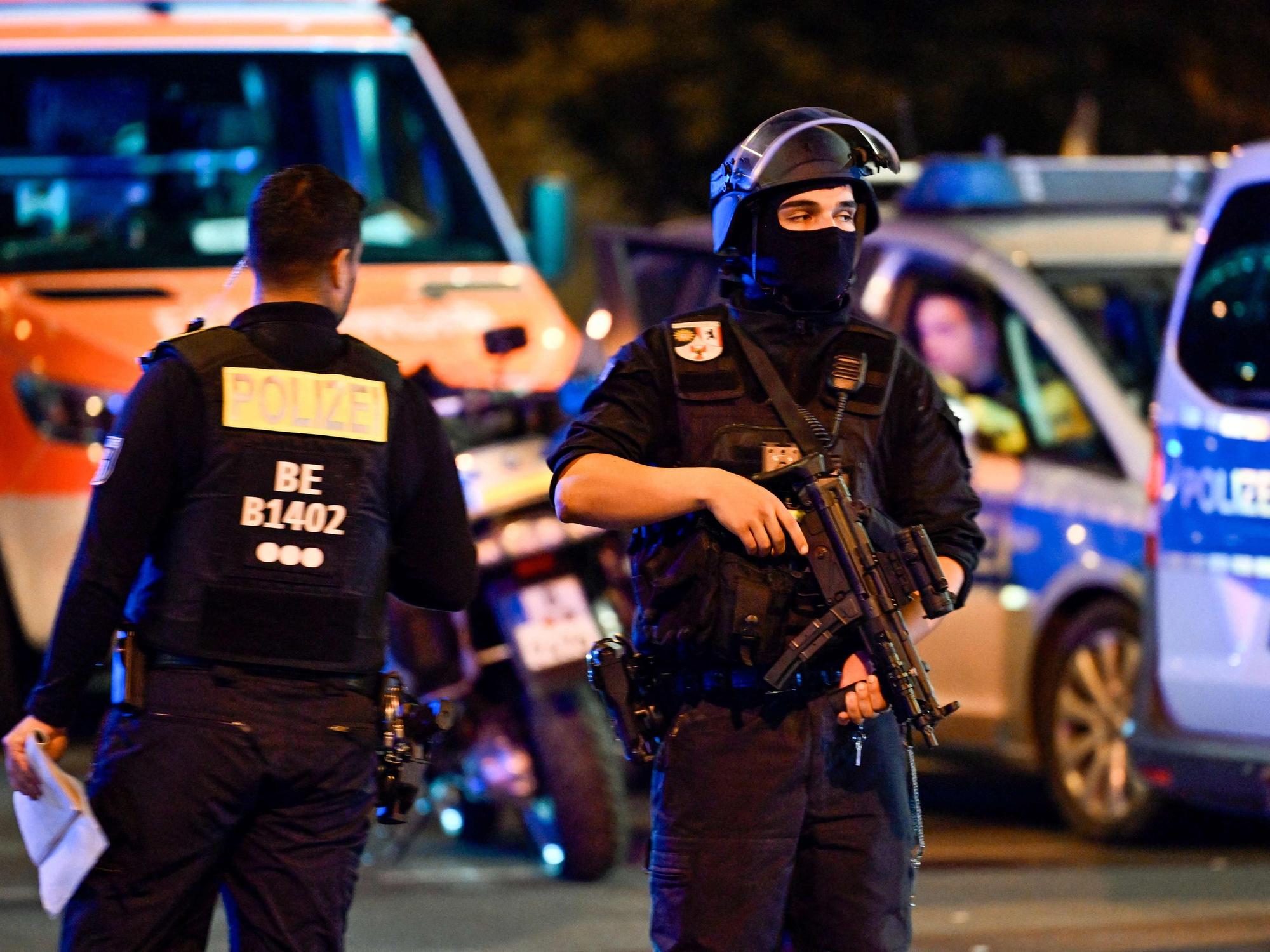 Bewaffnete Polizisten stehen in der Nähe des Tatorts, an dem am 25. Juli 2026 am Rande der Christopher-Street-Day-Parade (CSD) in Berlin eine Person getötet und etwa 16 weitere verletzt wurden, nachdem ein Auto in die Menschenmenge gerast war.
