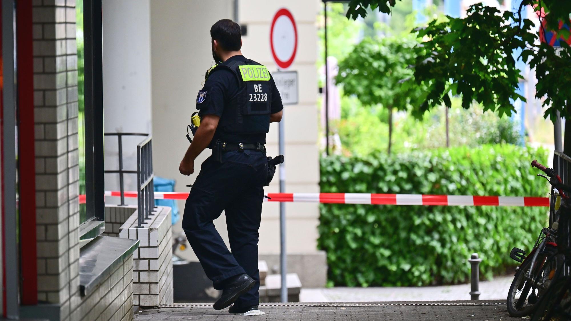 Ein Polizeibeamter geht an den Wohnblöcken vorbei, in denen in der Nacht eine Wohnung durchsucht wurde. Am Rande des Christopher Street Day in Berlin war das Fahrzeug in eine Menschenmenge gefahren.