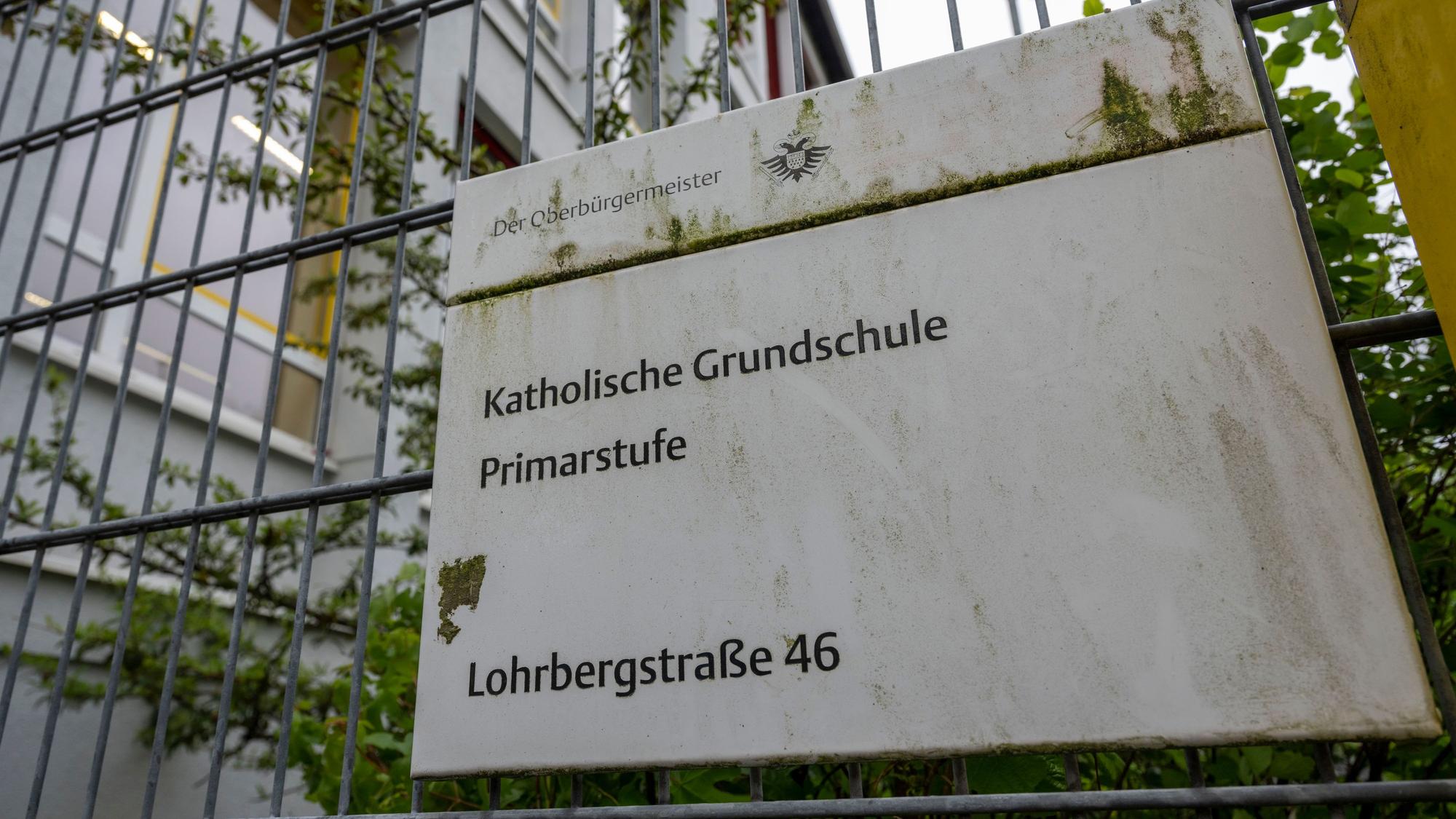 Ein Schild an einem Gitter weist auf die Grundschule Lohrbergstraße in Klettenberg hin.